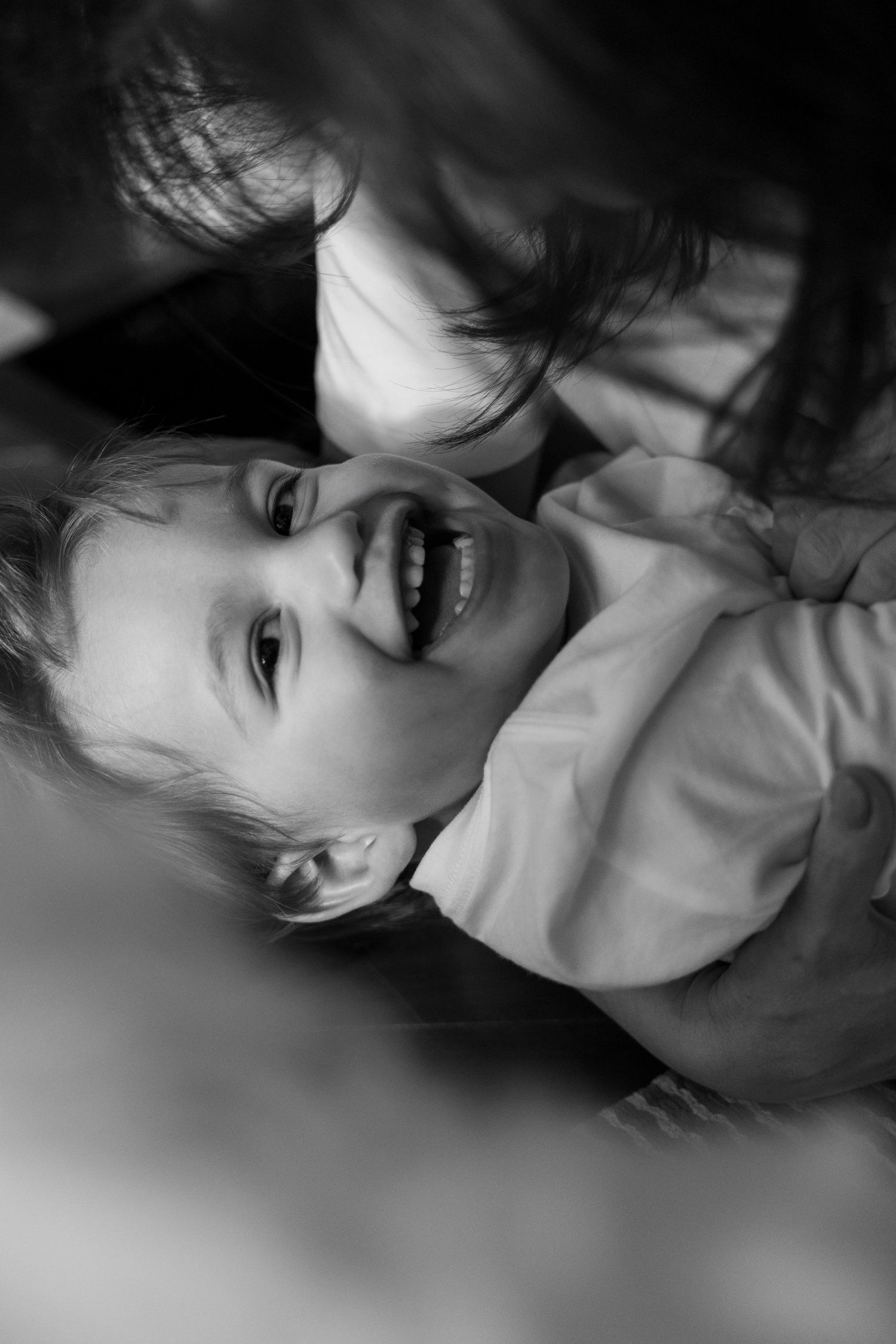 Black and white close-up portrait showing gentle expressions in dramatic lighting.