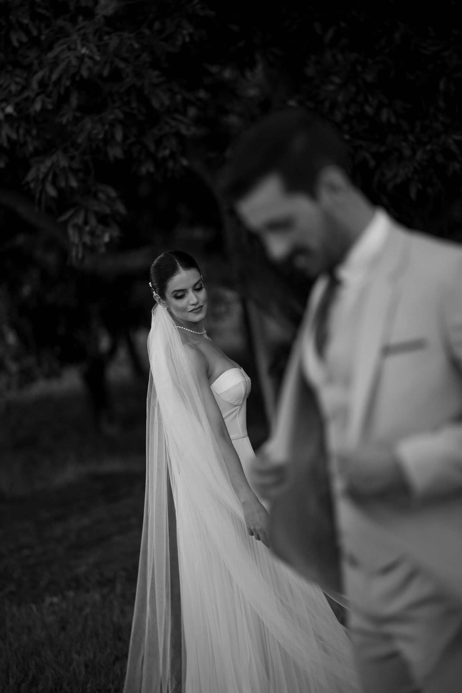 Artistic black and white wedding photography in a garden setting.