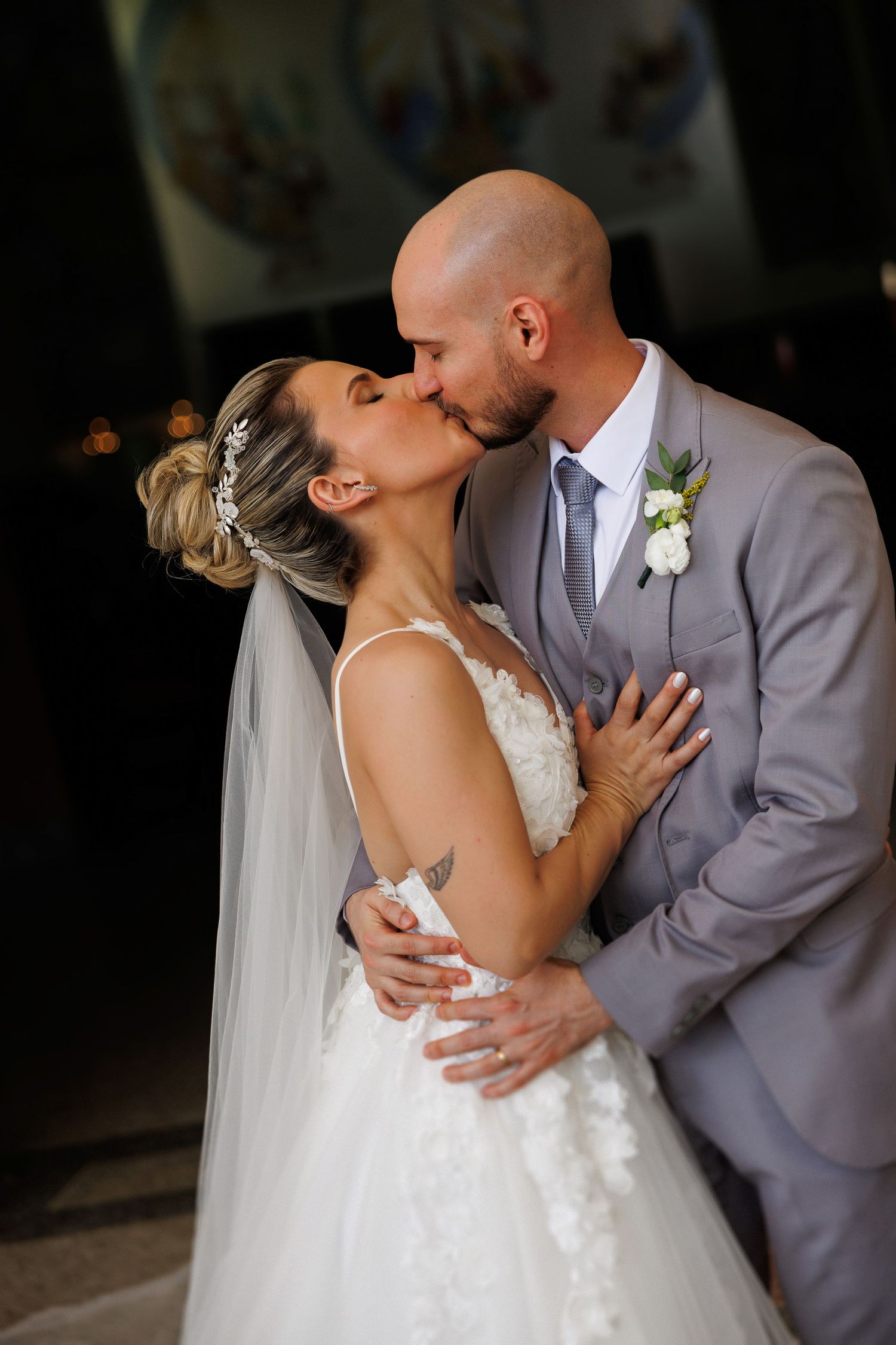 Romantic wedding portrait with couple embracing in elegant attire.