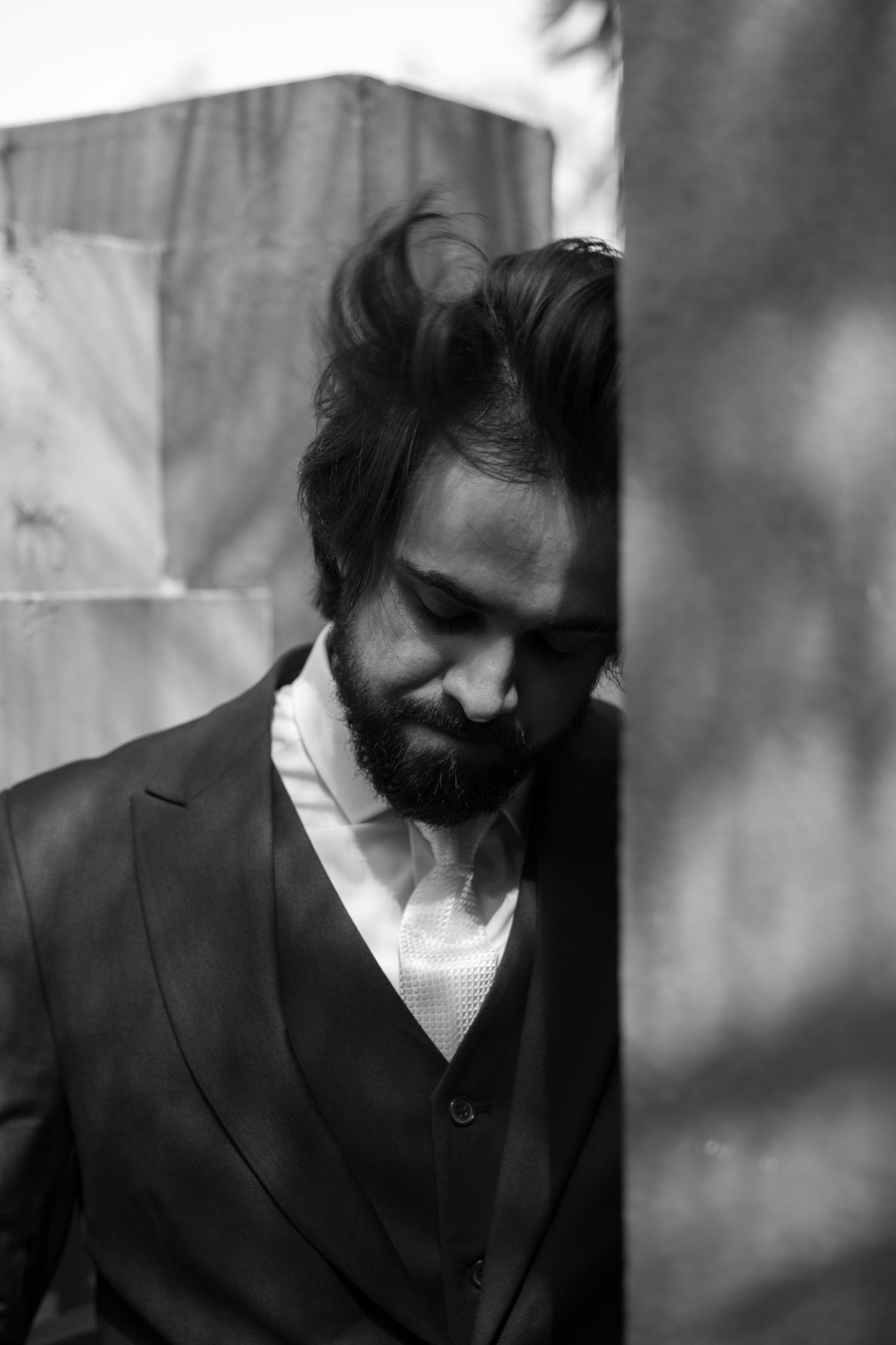 Artistic black and white portrait of a bearded man in formal attire.