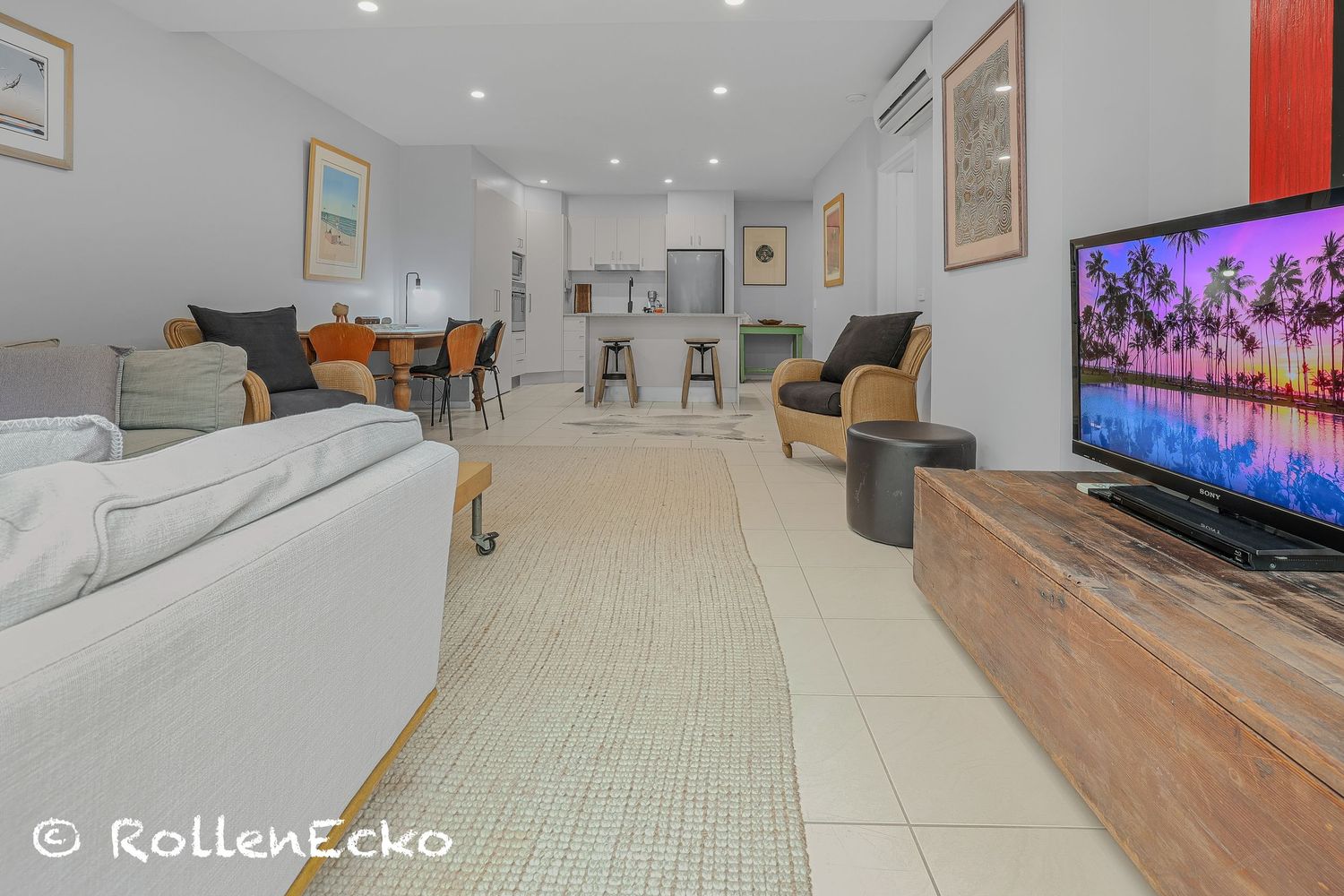Bright modern Airbnb lounge and kitchen with open plan layout, cozy seating, dining area and warm lighting showcasing inviting holiday accom