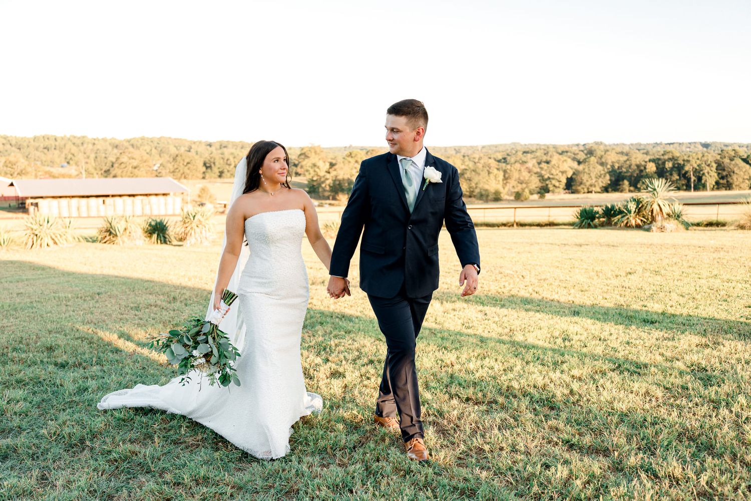 A bride and groom share romantic moments in a sunlit field with golden grass.  Wedding Photographer tyler tx