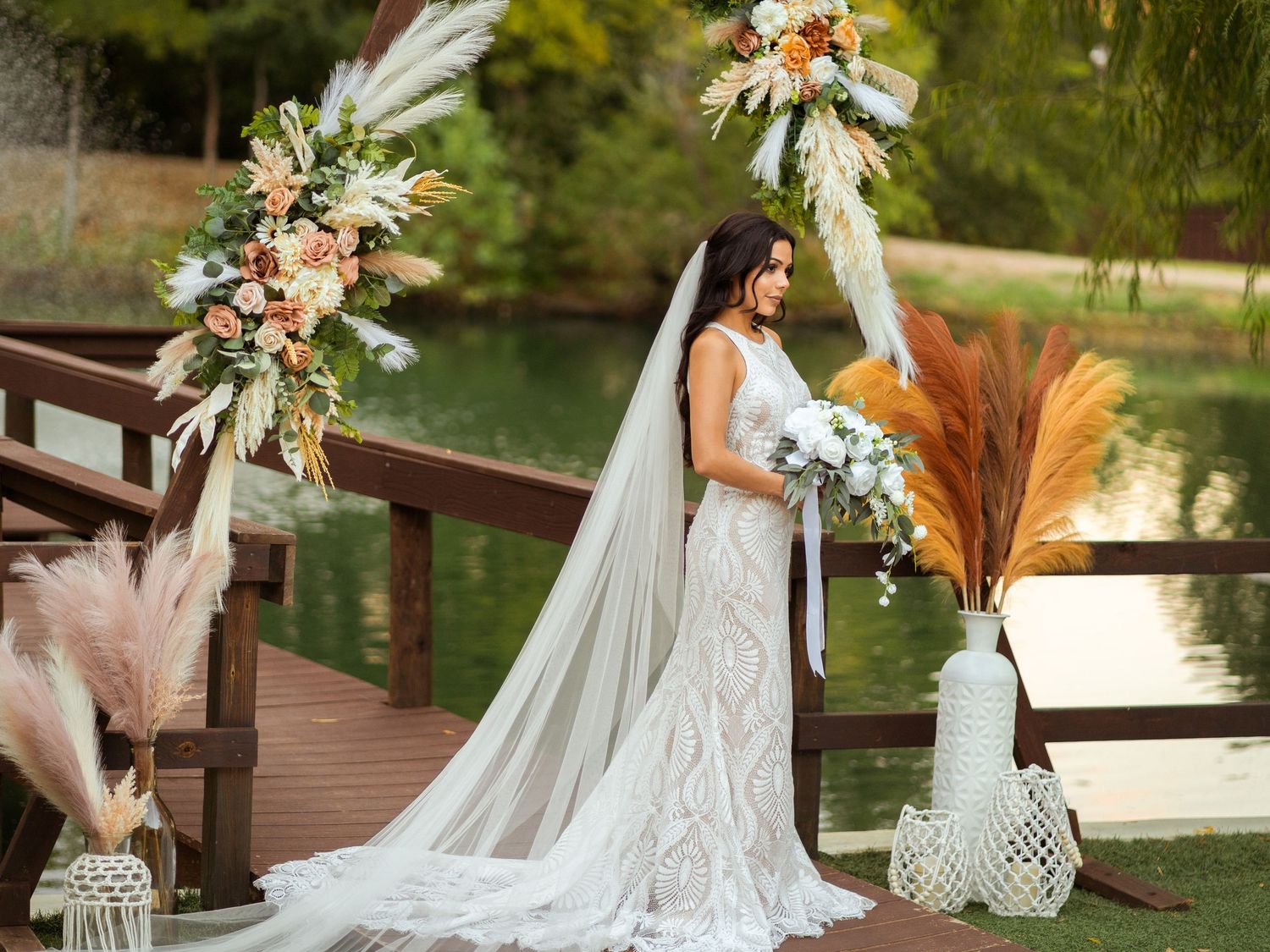 Wedding decor with floral arrangements and white lanterns along outdoor walkway.