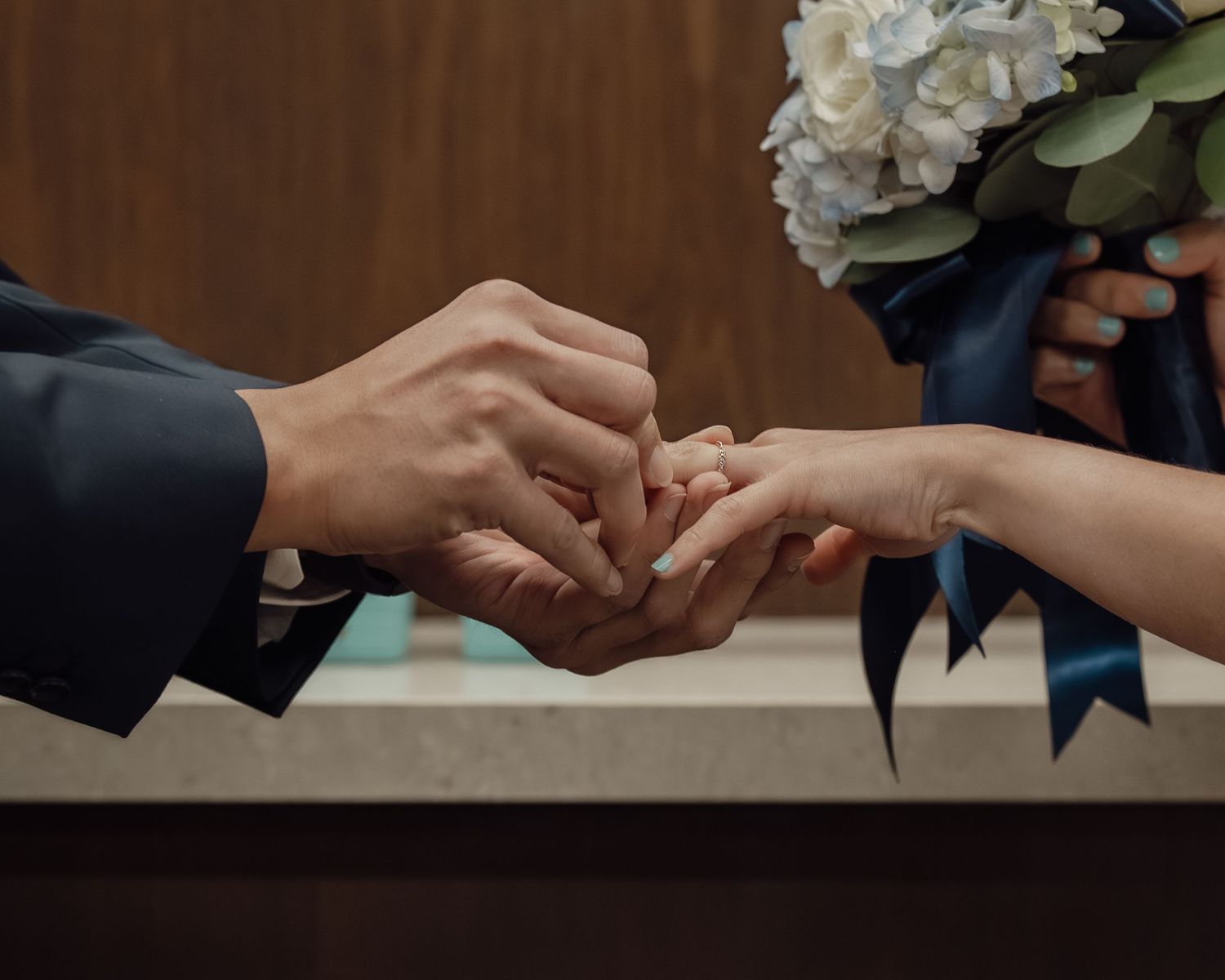 Close-up shots of hands exchanging rings during a wedding ceremony.
