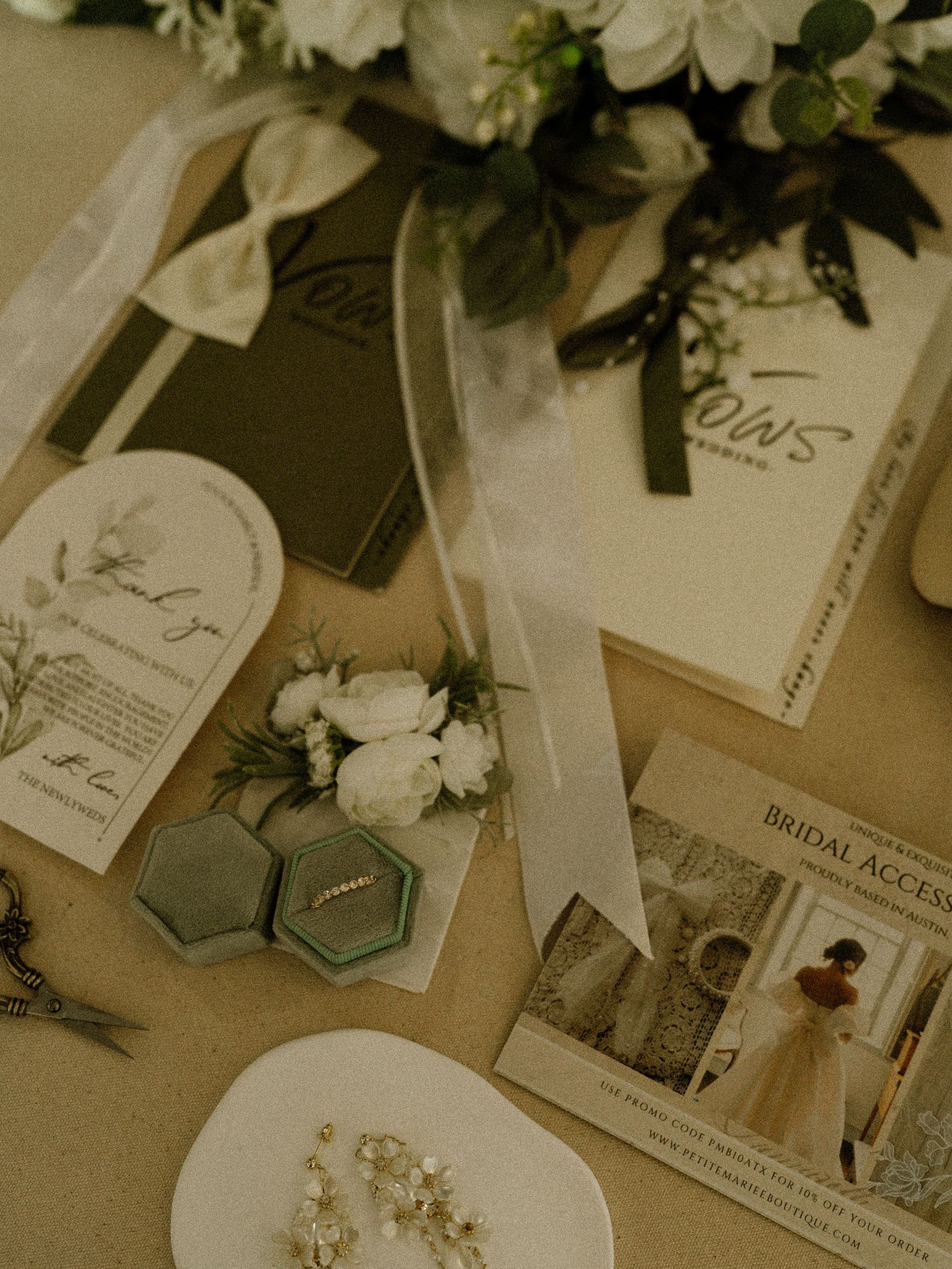 Wedding stationery flat lay with floral arrangements and vintage-style name cards.