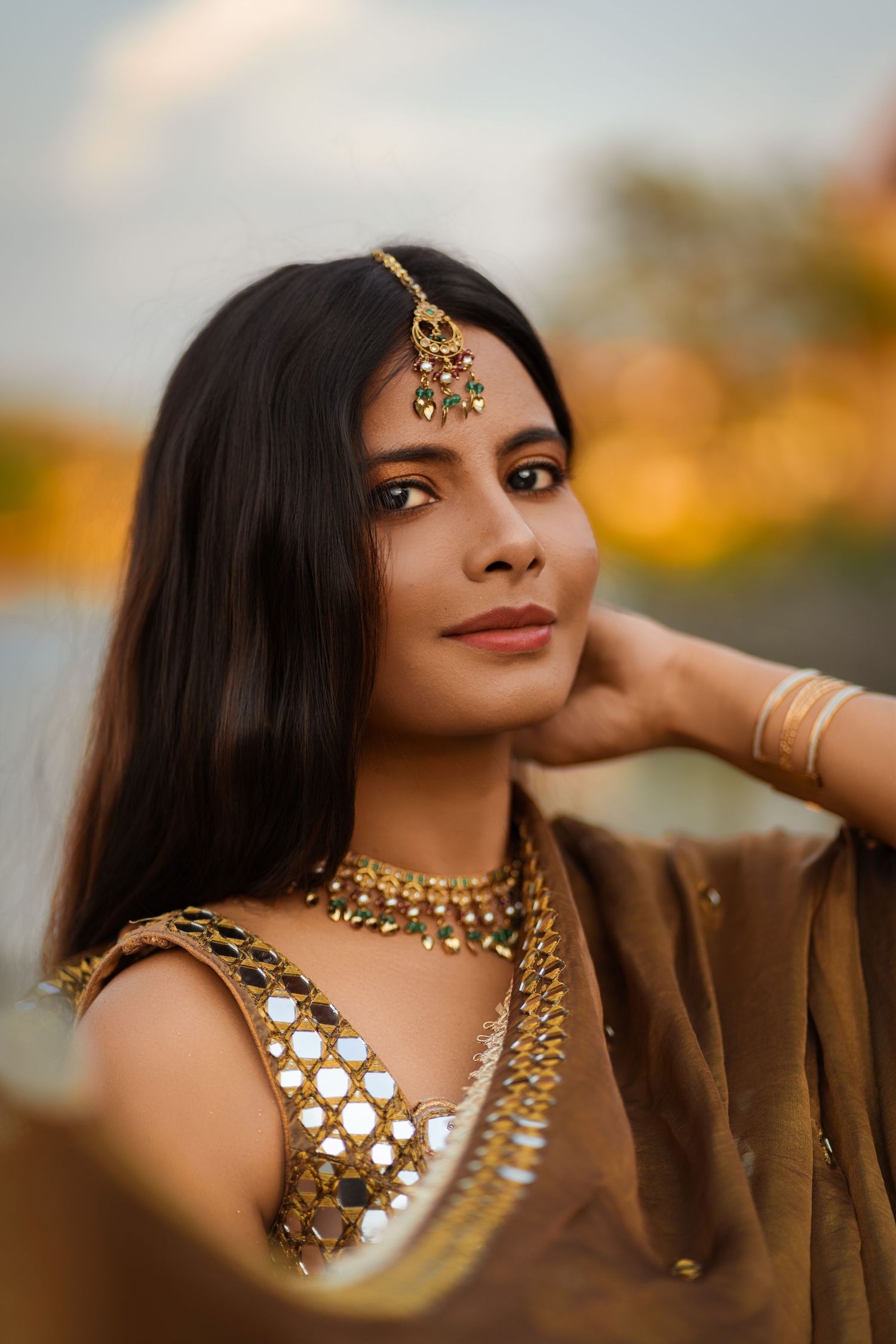 Close up portrait of woman in traditional Indian jewelry at golden hour.