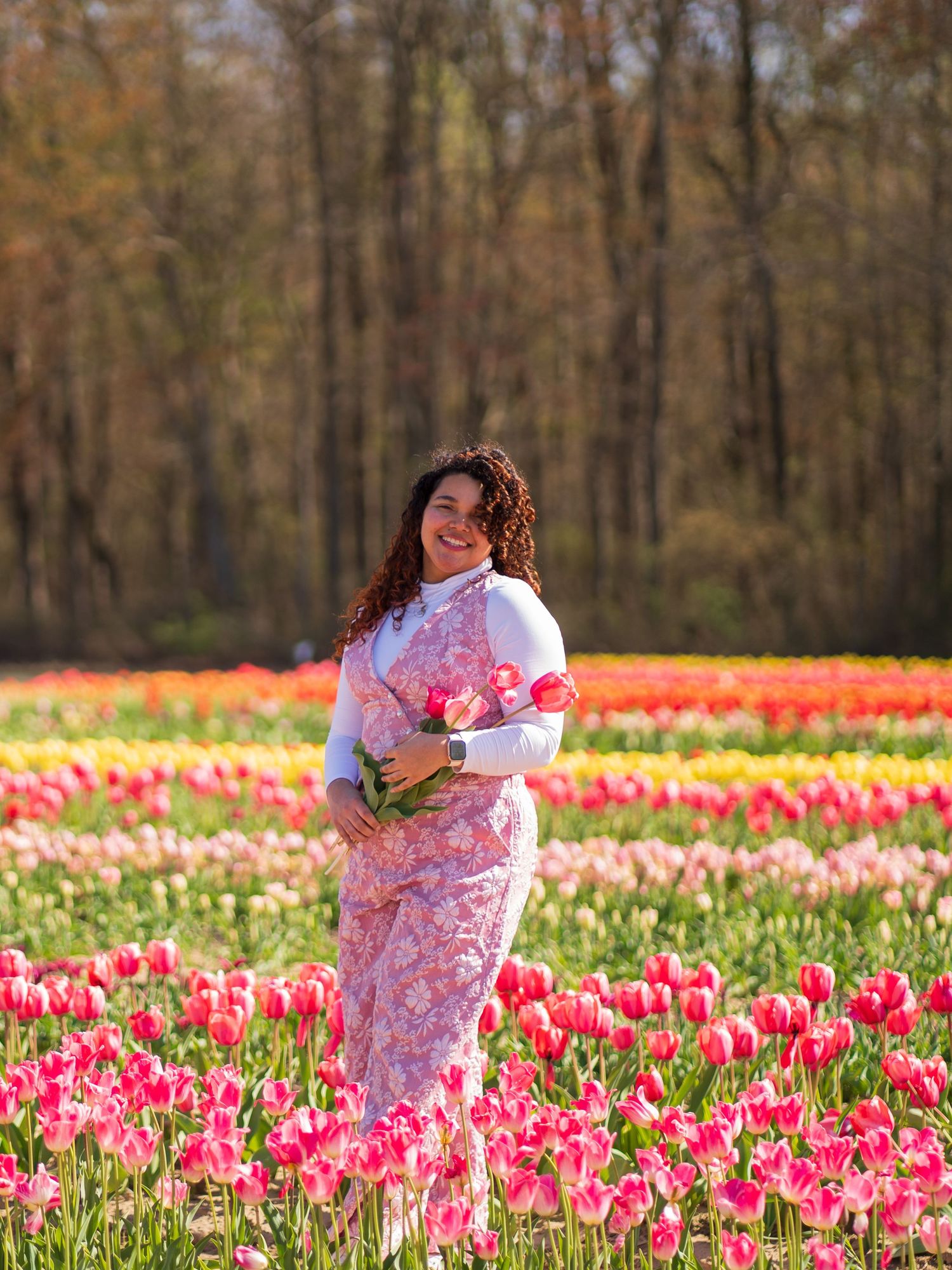 A spring photography session in a vibrant field of pink and red tulips.