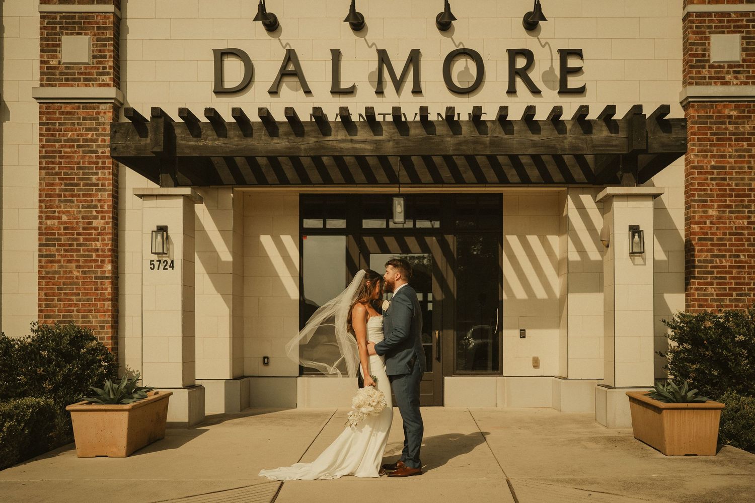 Bride and groom standing together in front of the Dalmore venue entrance on their wedding day.