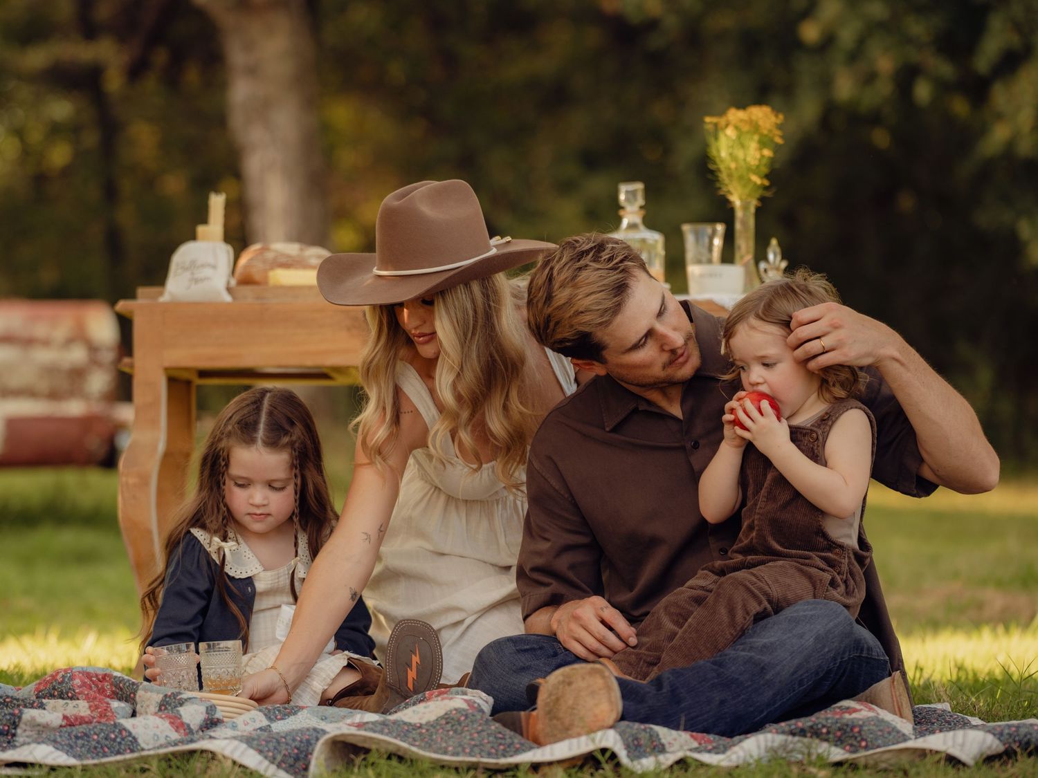 Candid family moments captured during outdoor picnic session in golden sunlight.