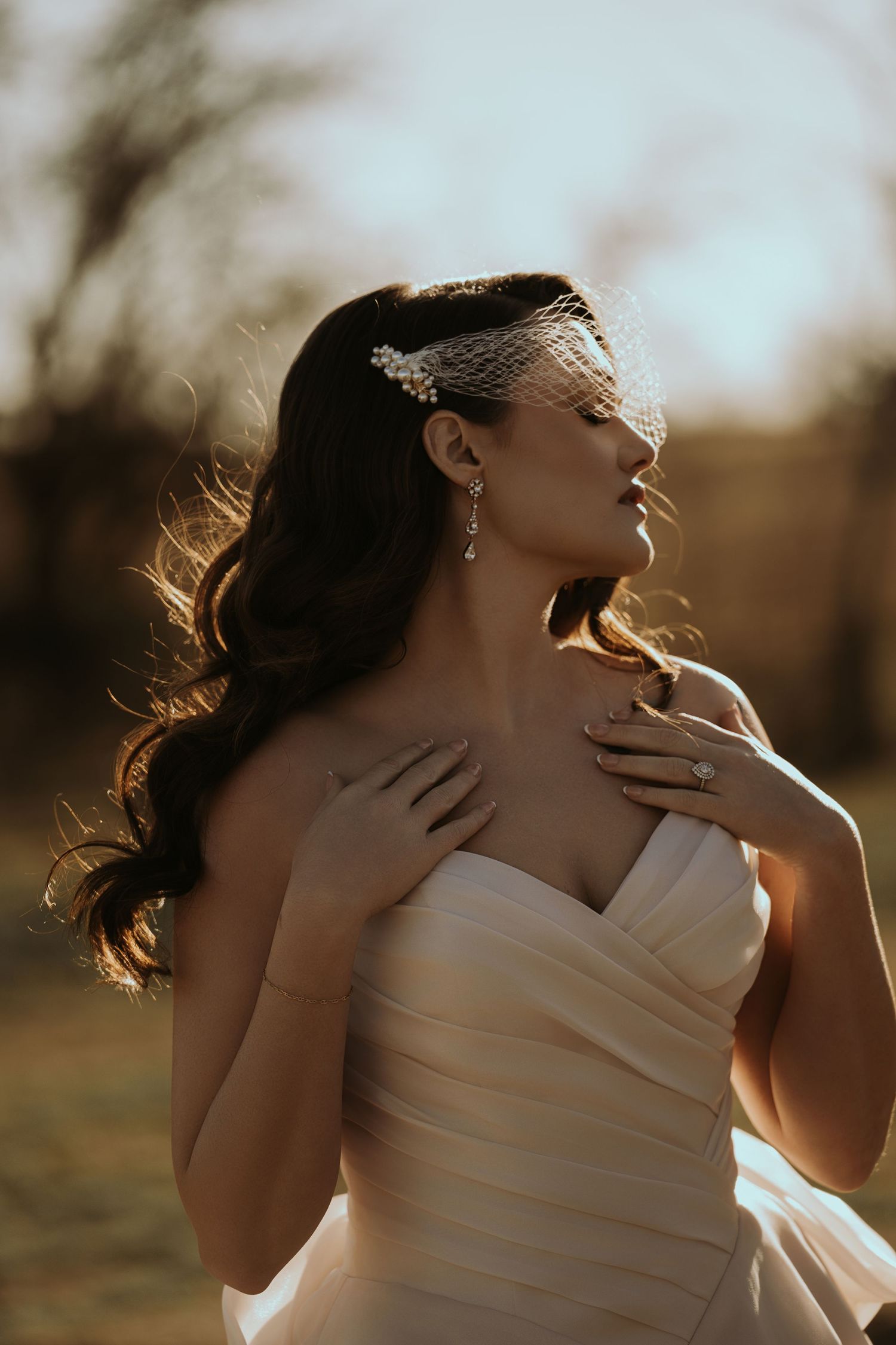 Artistic bridal portrait series with dramatic backlighting and flowing fabric.