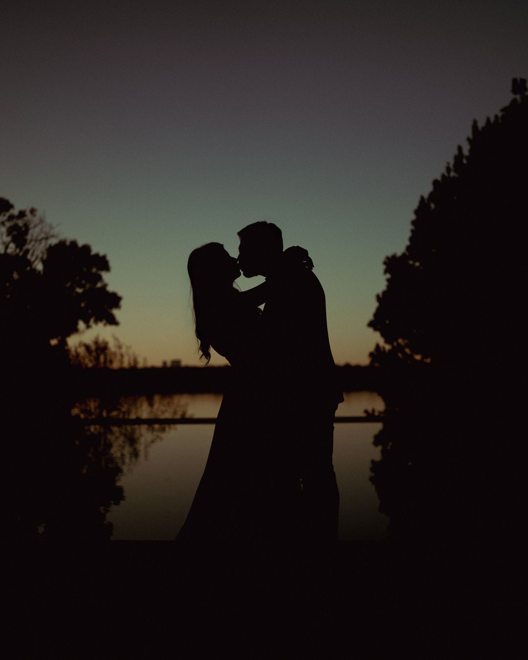 Silhouettes of a couple against a sunset sky creating a romantic atmosphere.