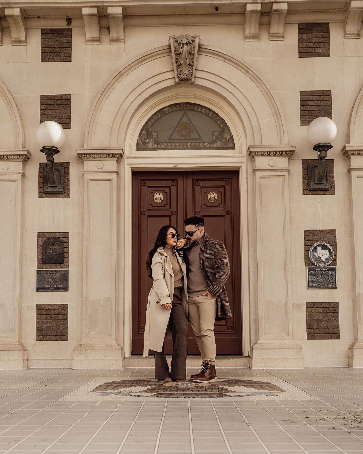 Architectural engagement photos on classic stone building steps with arched doorways.