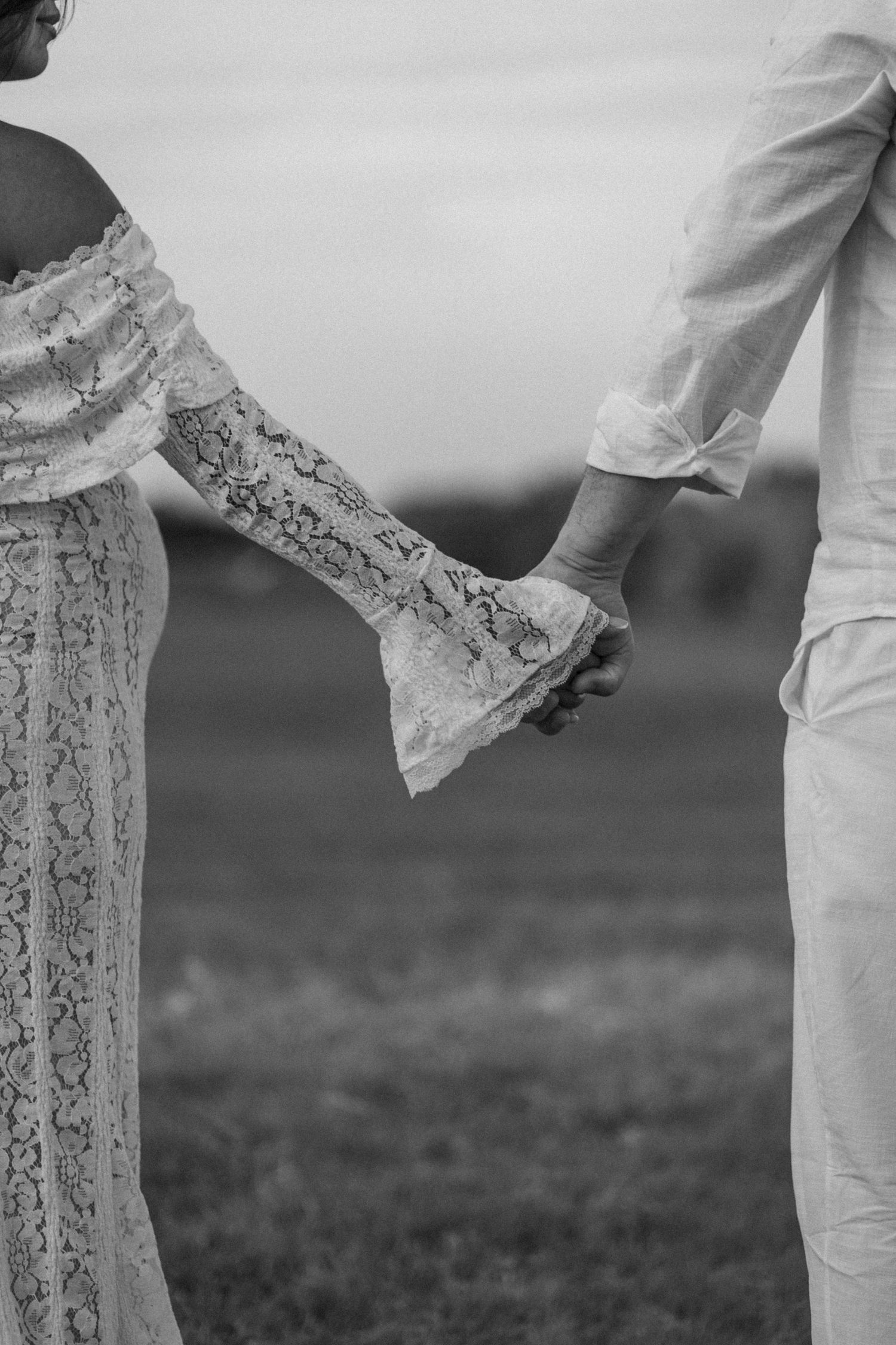 Close-up shot of hands holding each other against a blurred outdoor background.
