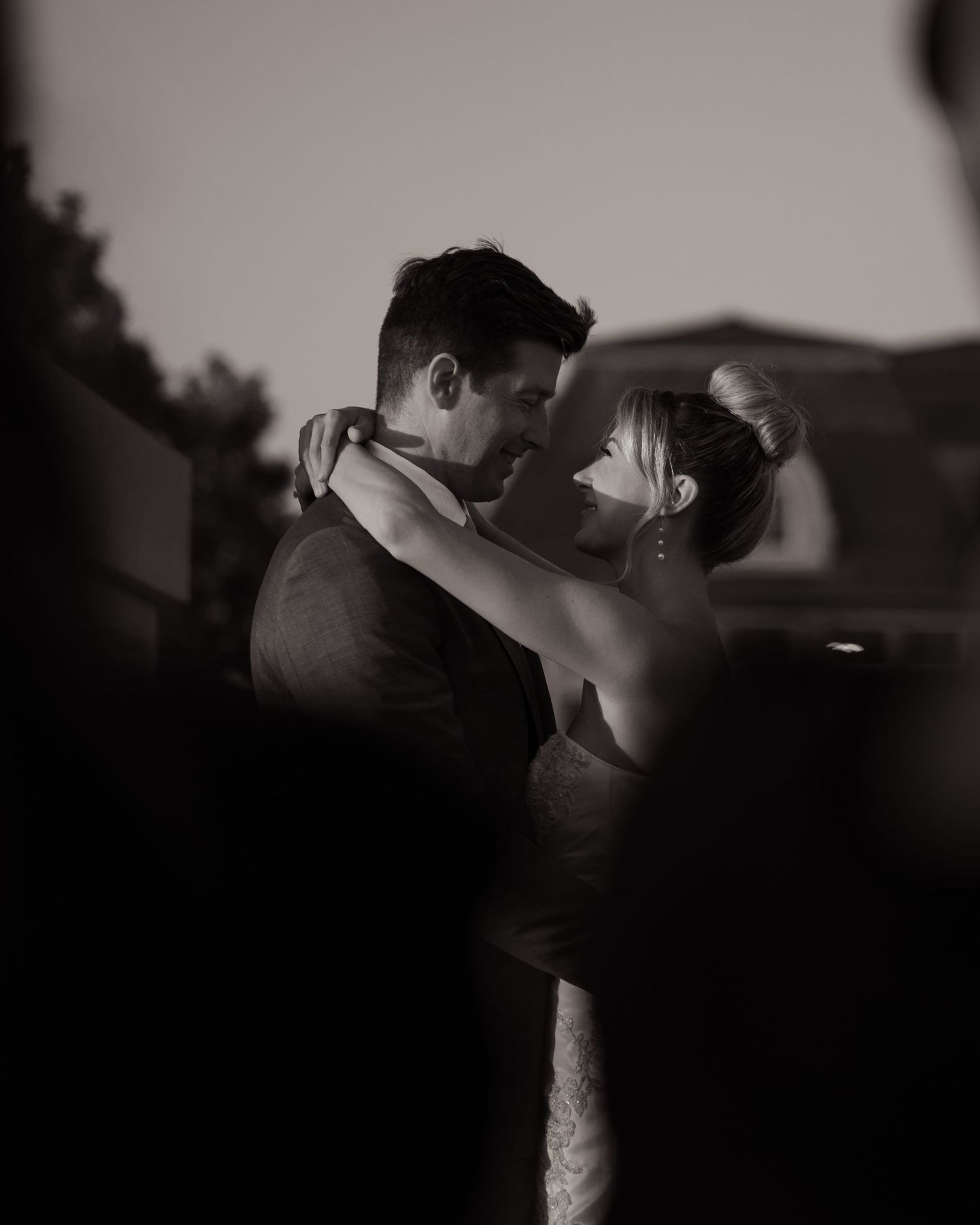Dramatic black and white silhouettes of a romantic wedding couple embrace.