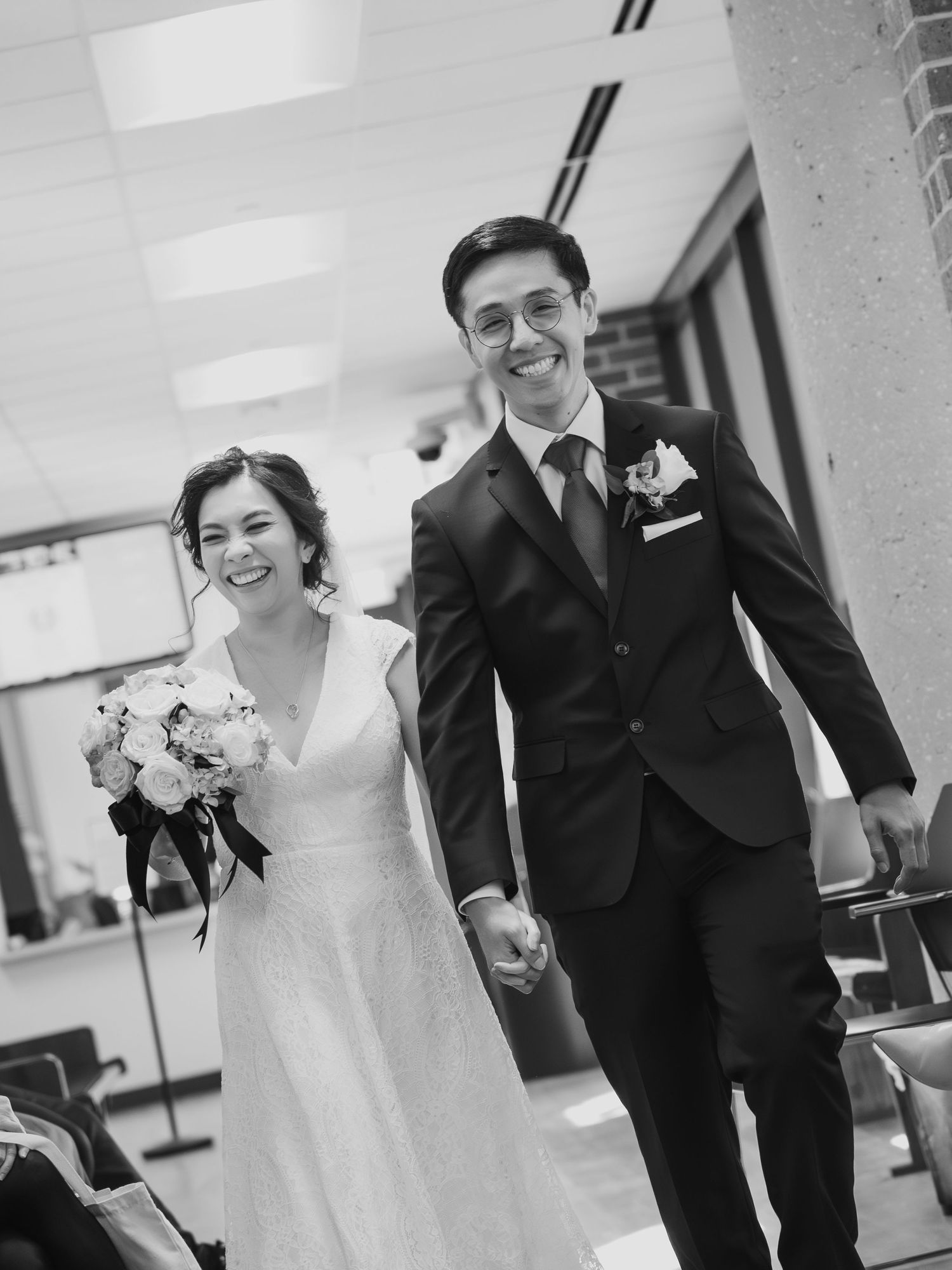 A black and white photo series showing a couple walking and laughing together during their wedding day.