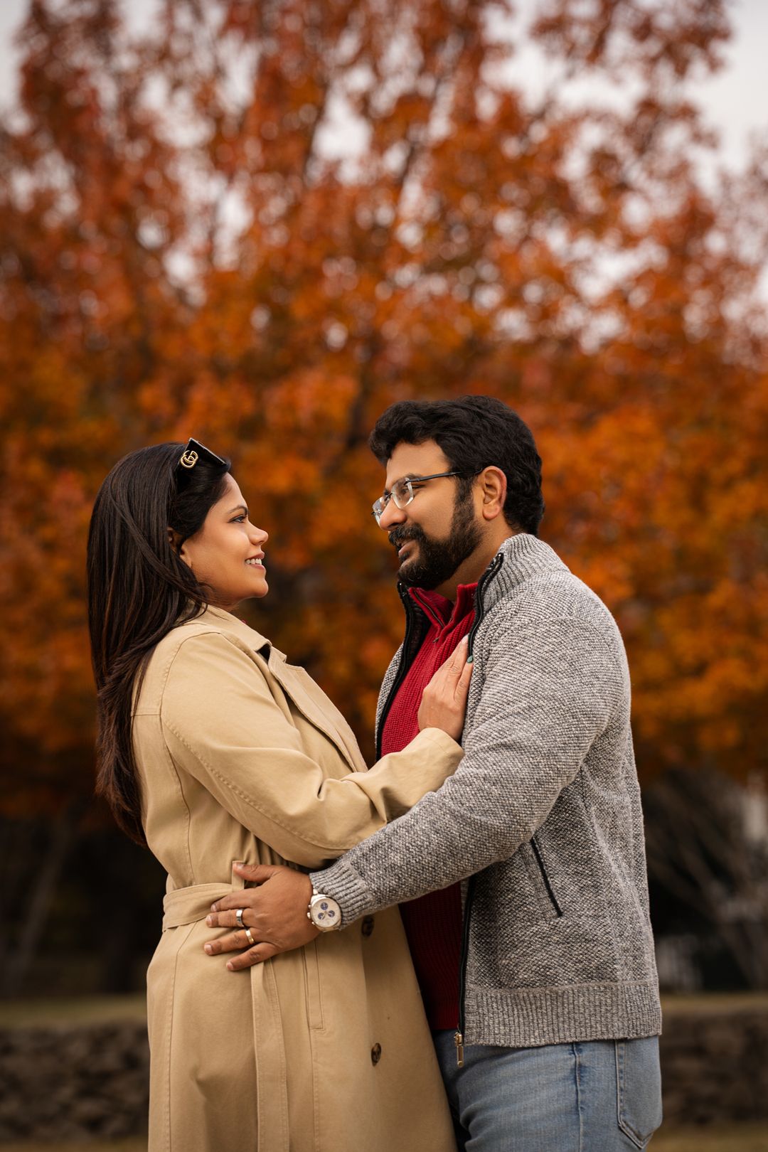 Romantic autumn engagement photos with vibrant orange foliage backdrop.