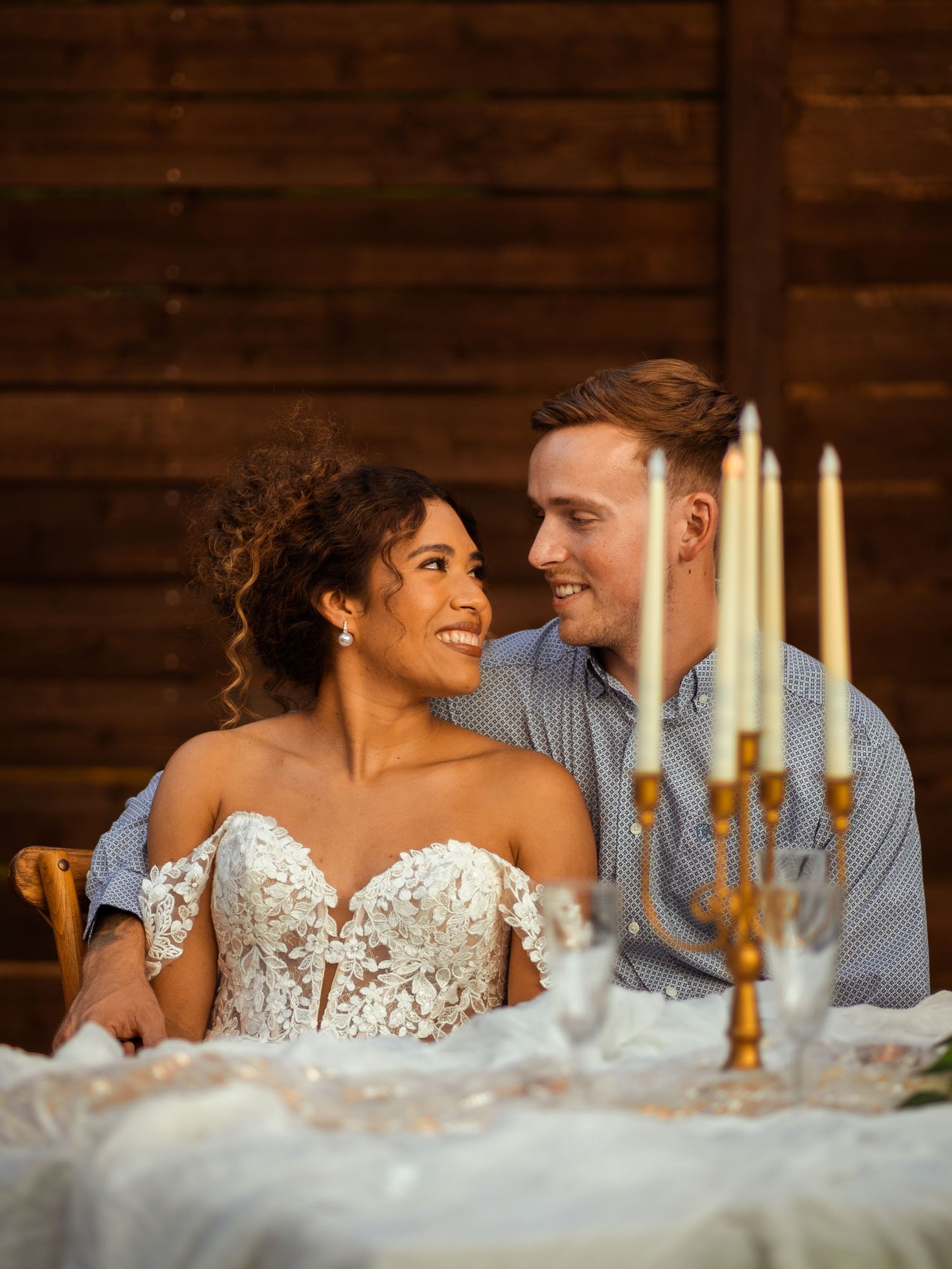 Intimate wedding reception scene with candlelit table setting and elegant decor.