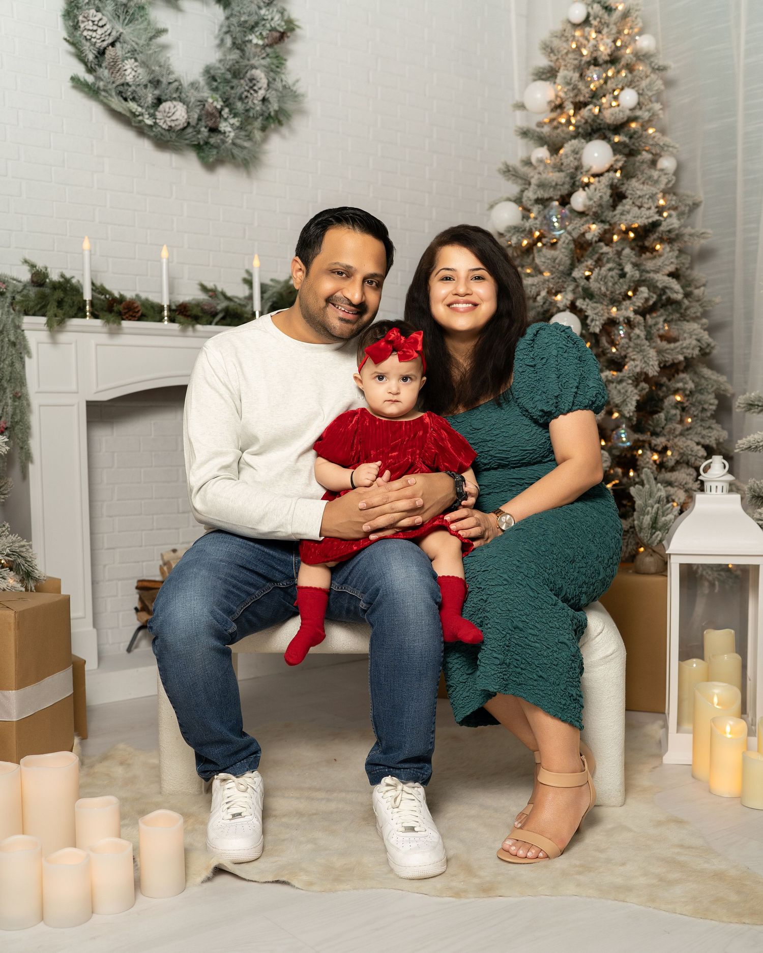 Family holiday photos with Christmas decorations and candles in cozy studio setting.