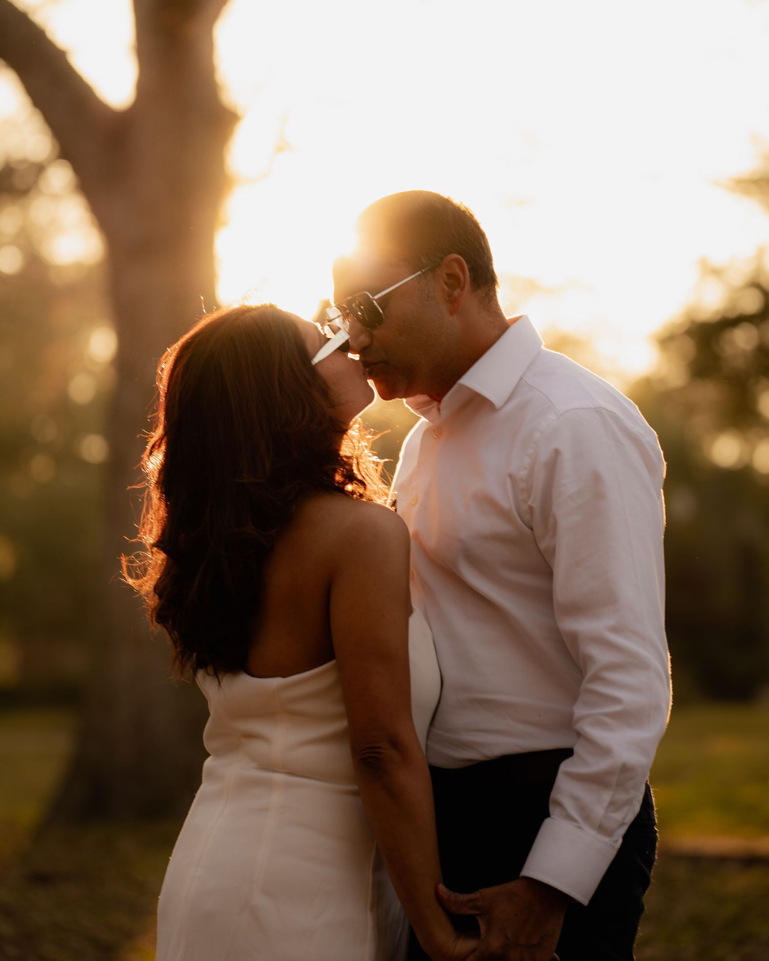 Romantic sunset silhouette portraits in a natural outdoor setting.