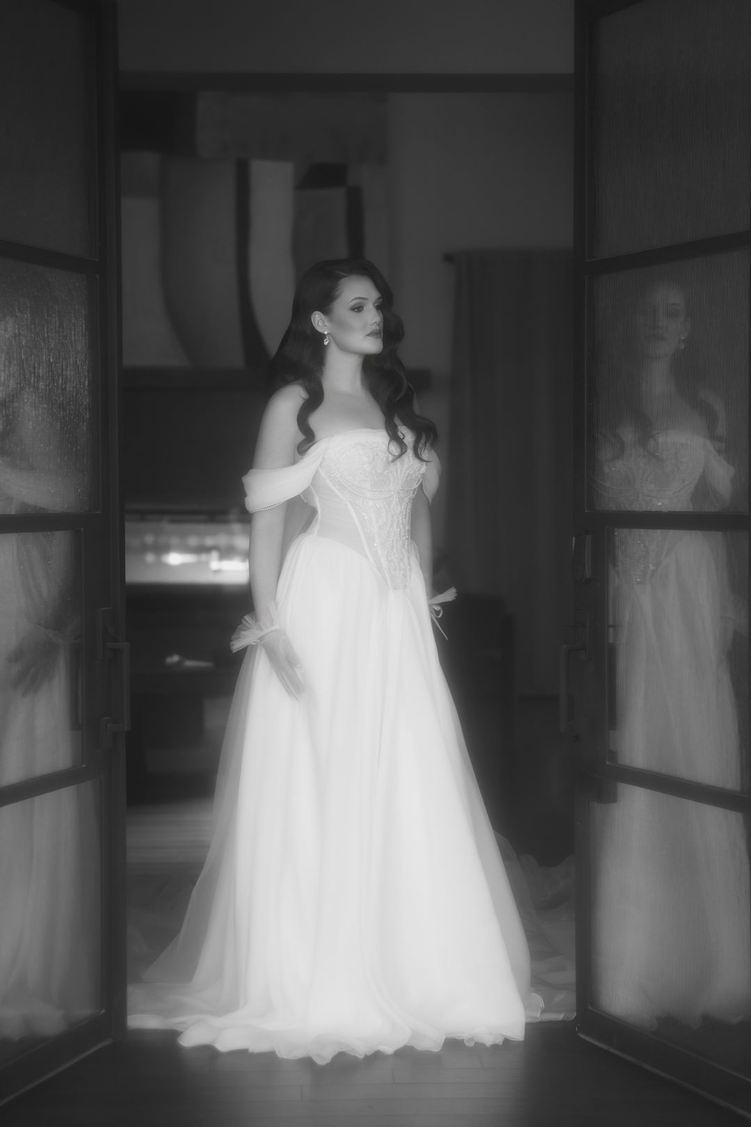 Ethereal wedding dress portraits in a moody hallway with dramatic lighting.
