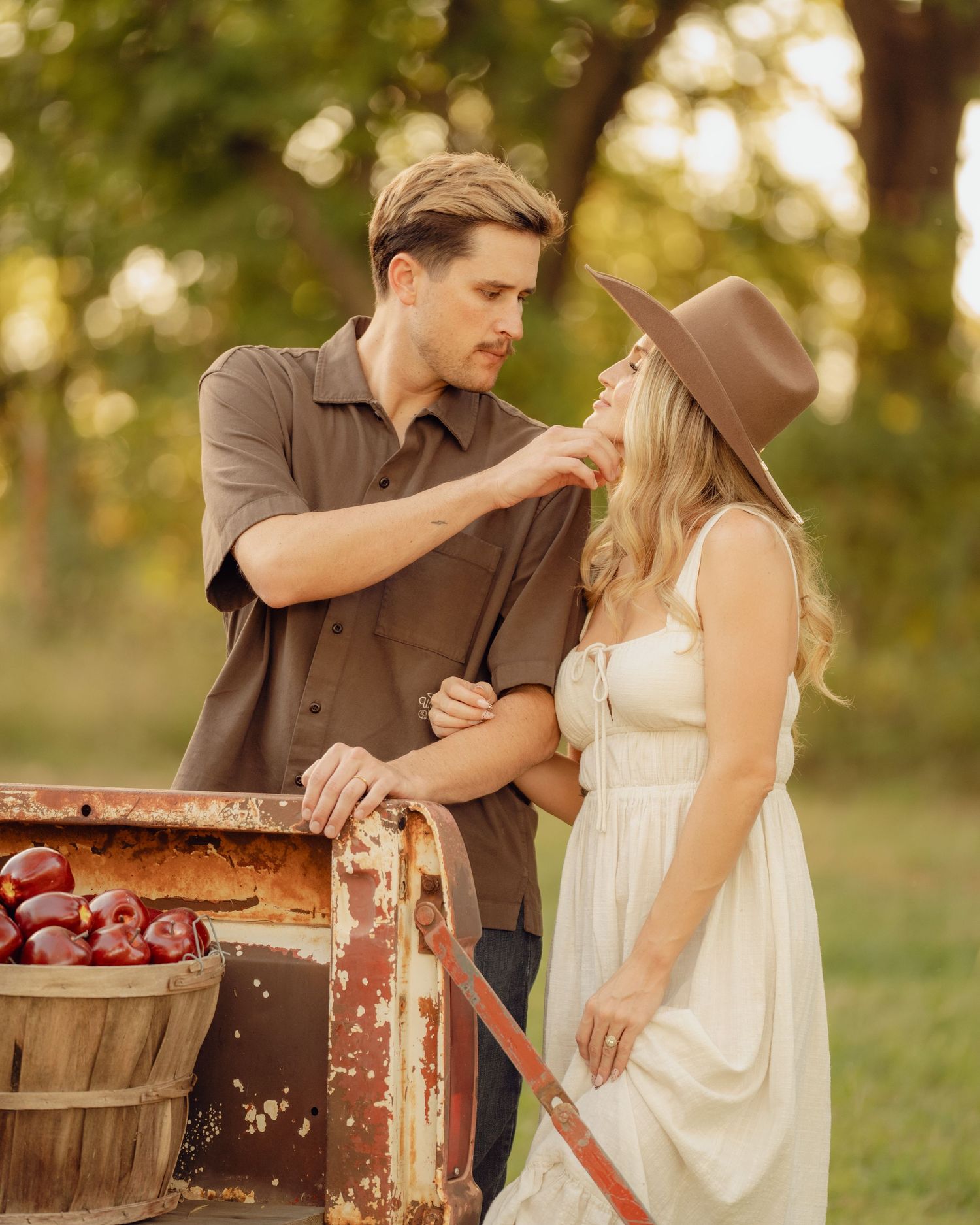 Romantic couple interacting with rustic wooden crates in golden afternoon light.