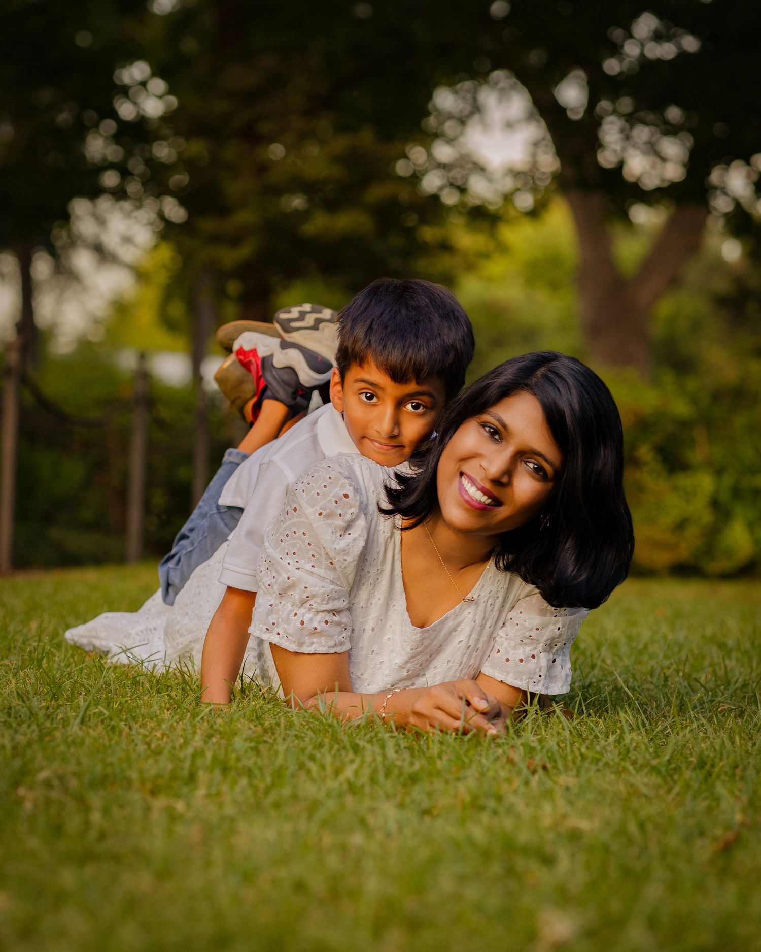 Children laying on grass during golden hour photo session.