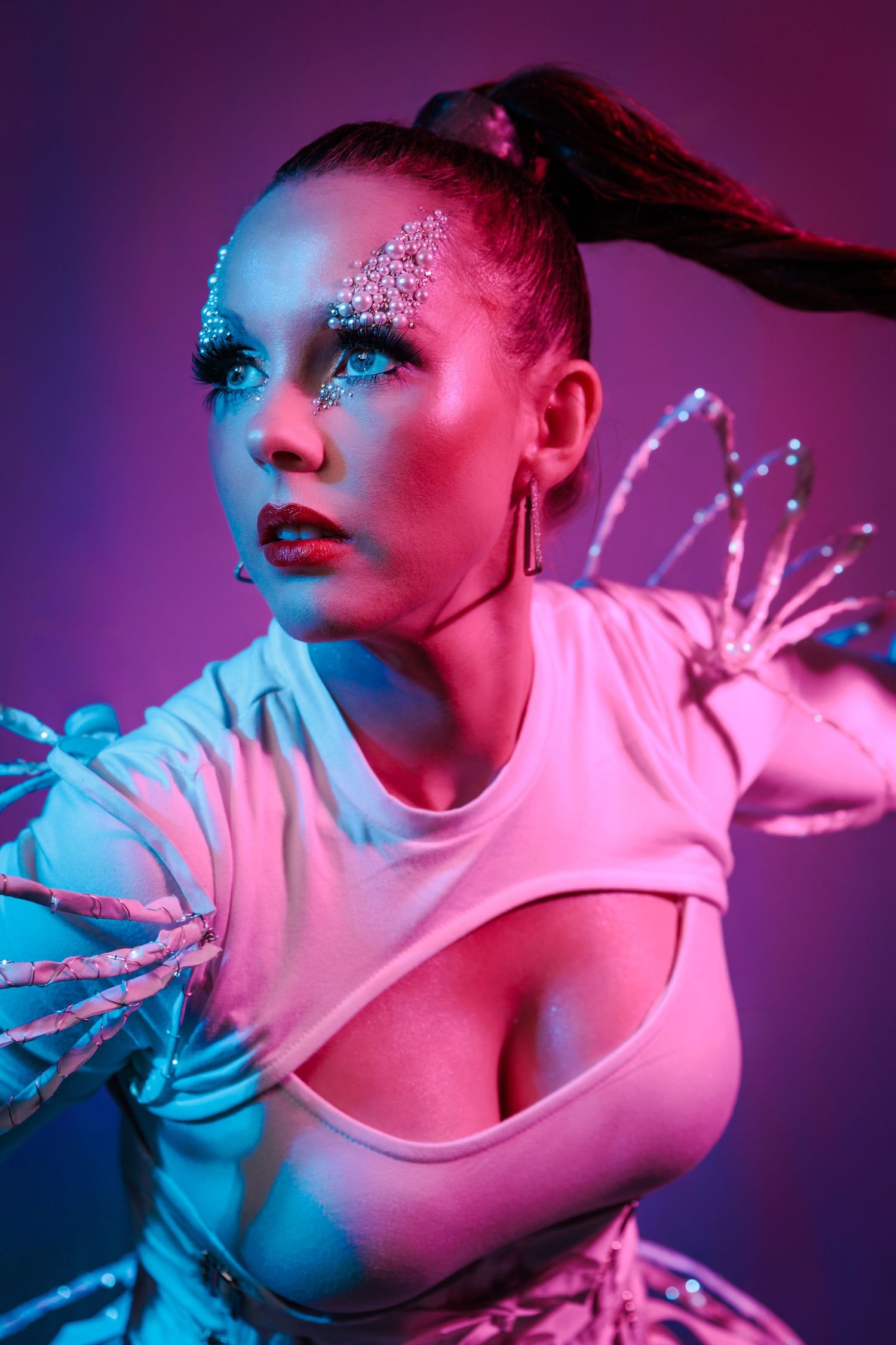 Artistic fashion portrait with dramatic neon pink and blue lighting showing dynamic dance-inspired poses.