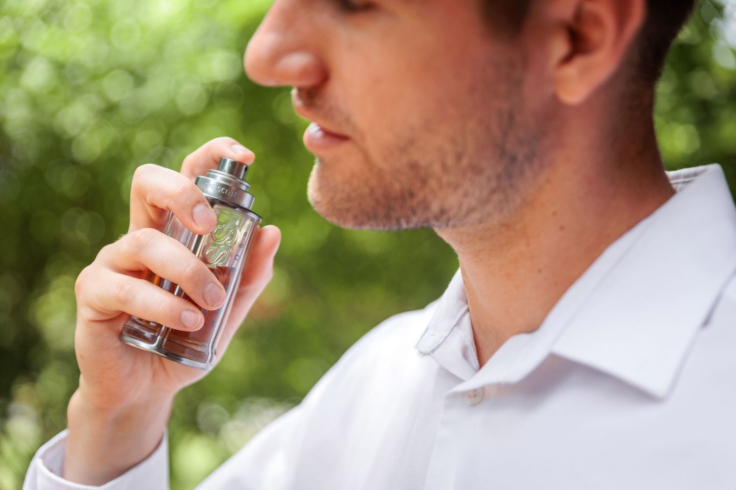Close-up shot of someone in a white shirt wearing a green-faced watch.