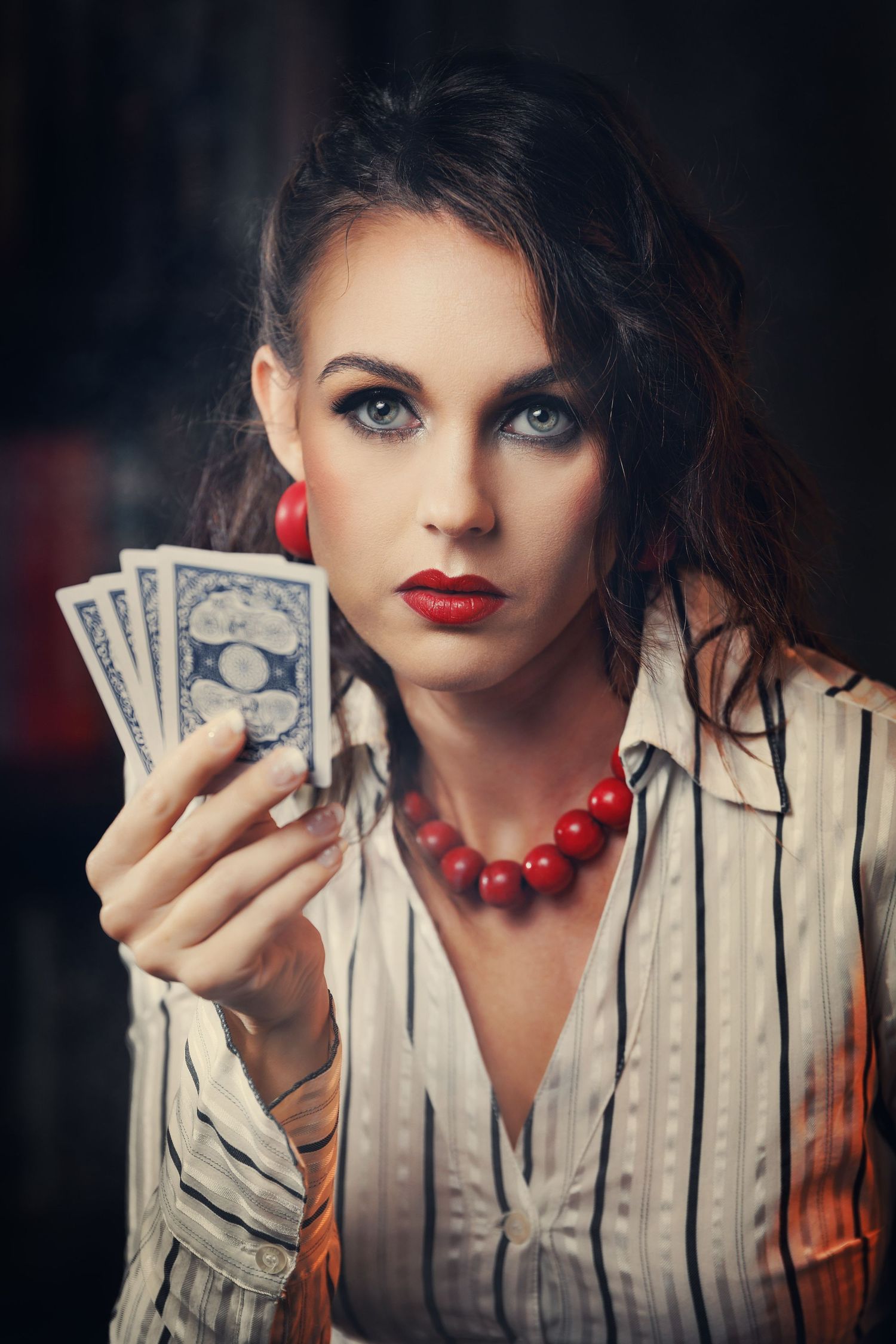 A dramatic portrait series showing someone in a striped blazer with red beads holding money against a dark background.