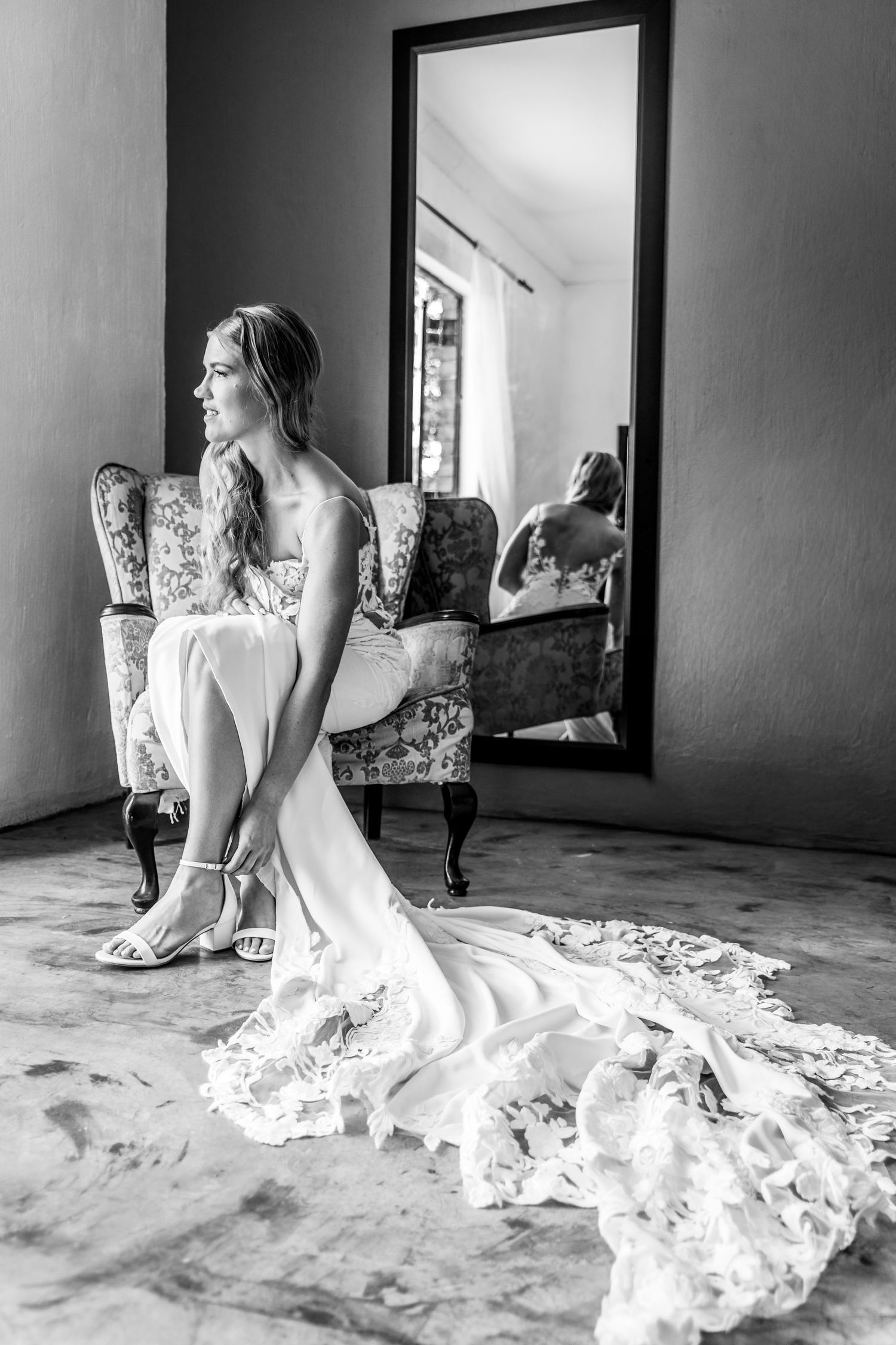A black and white photo series shows a woman in a flowing lace dress posing gracefully on the floor.