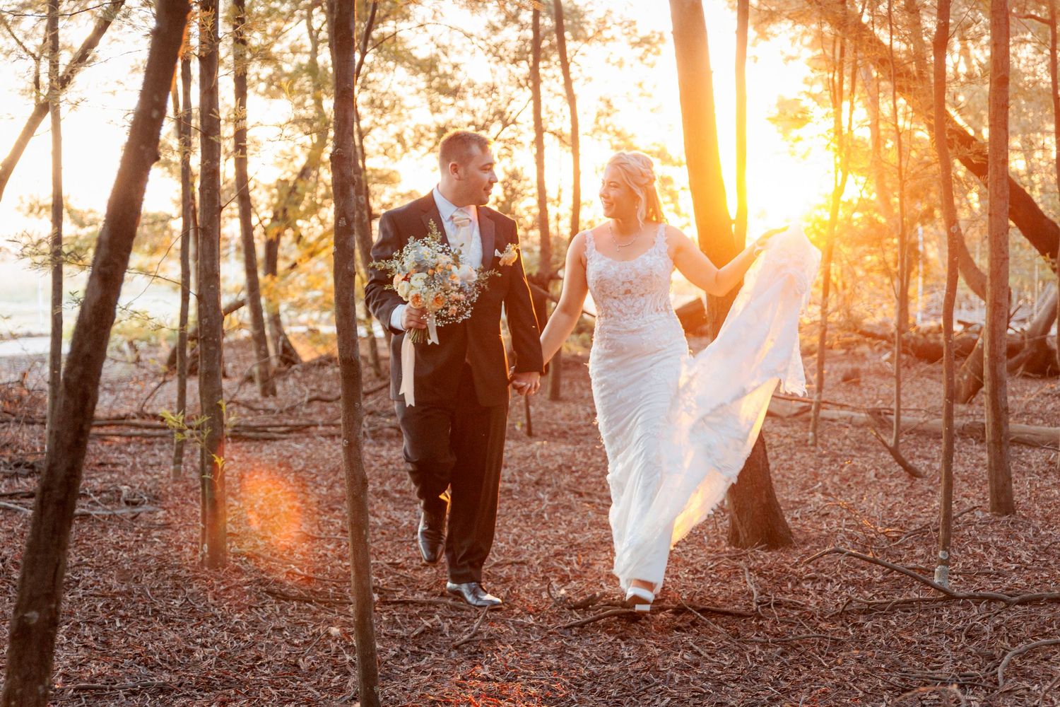 Romantic sunset wedding photos among trees with golden light filtering through.