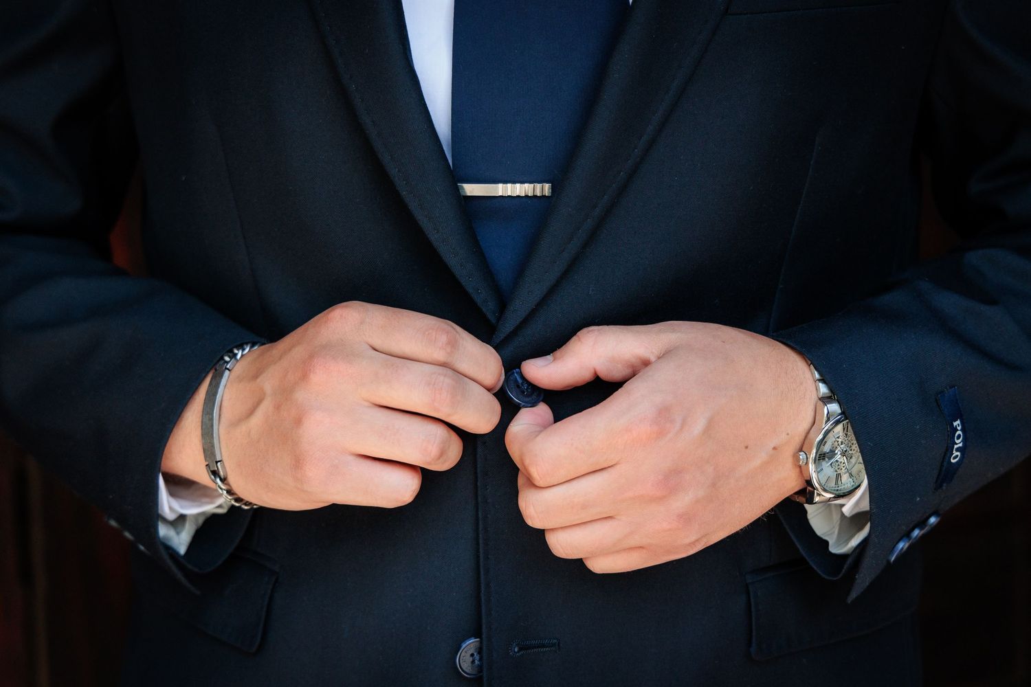Close-up details of formal attire showing buttons and suit jacket.