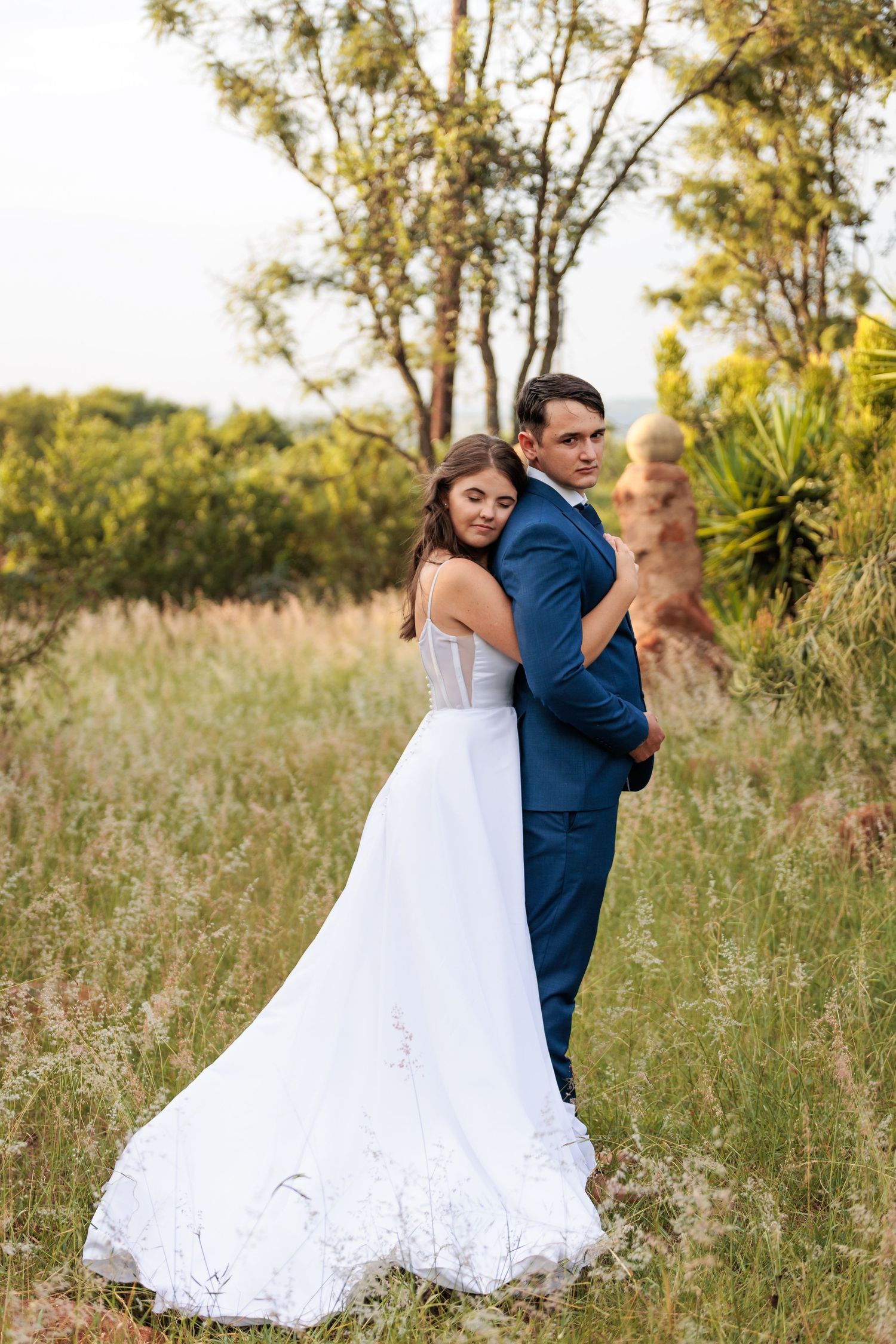 Newlyweds share intimate moments while dancing in a rustic outdoor setting.