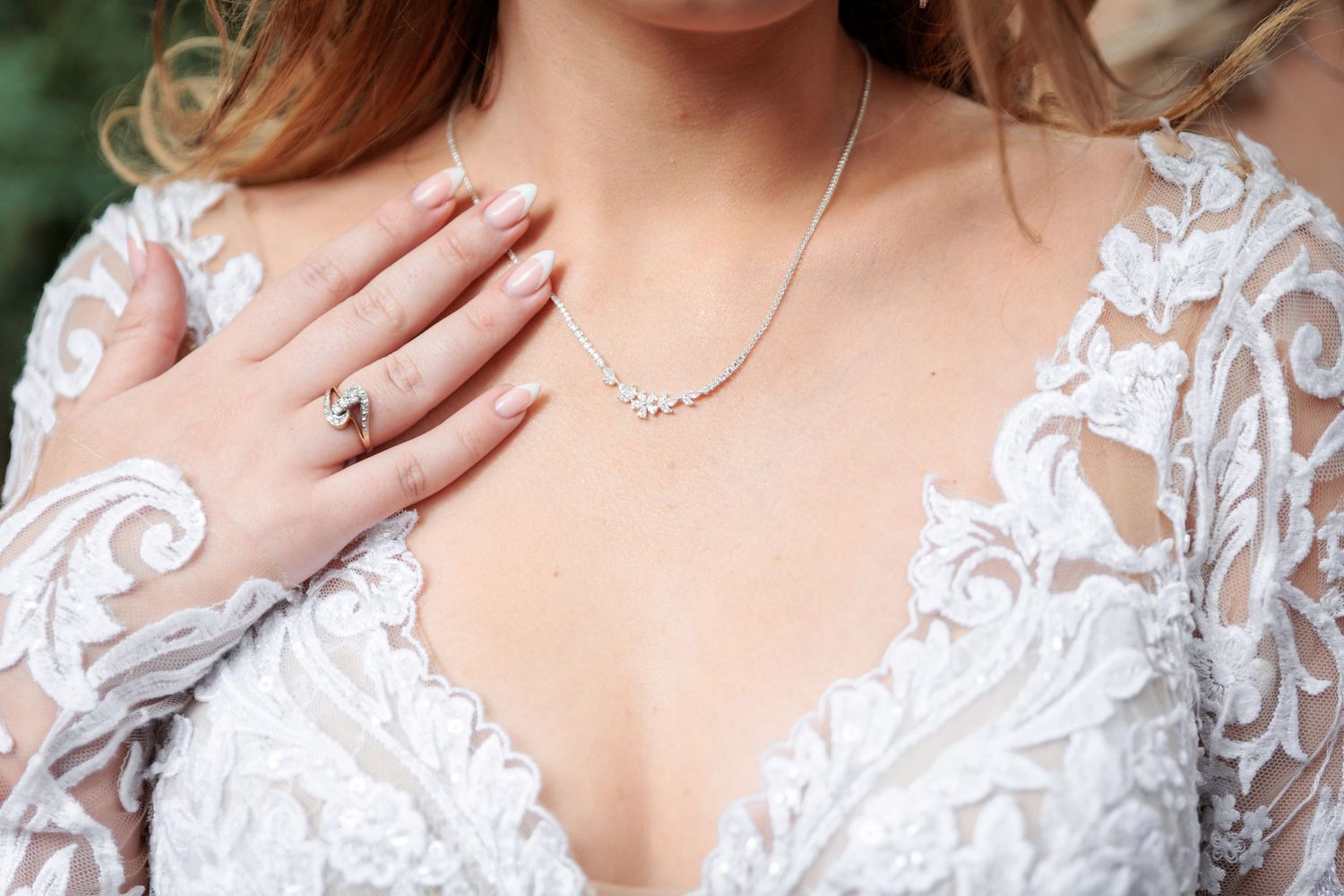 Close-up detail of intricate white lace wedding dress with delicate floral patterns.