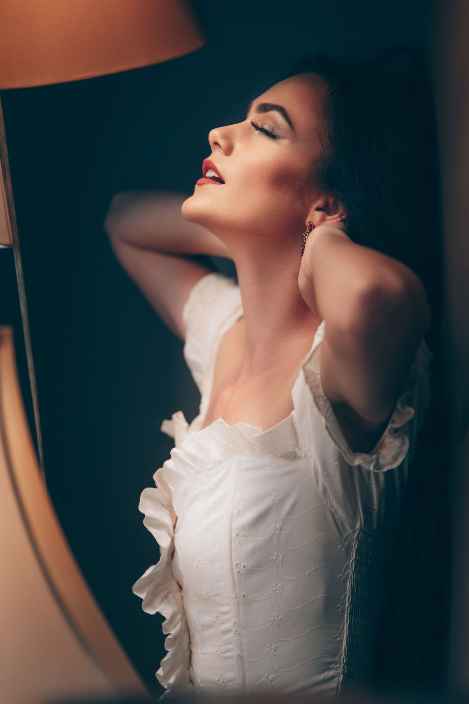 A dramatic fashion portrait series showing a person in a white ruffled dress posing against a dark background.
