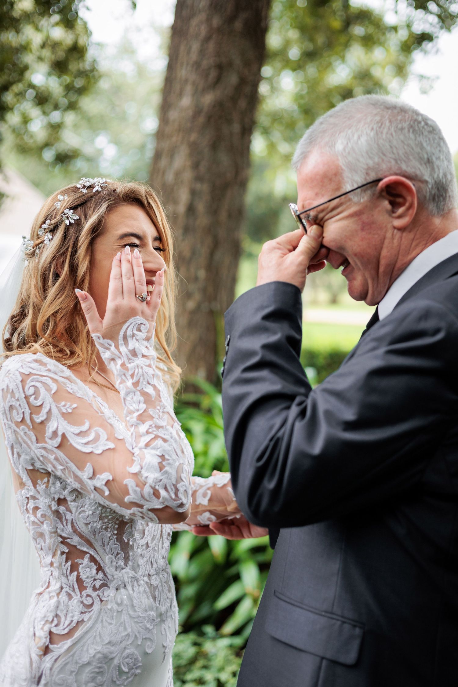 Emotional first look moment between bride and father in outdoor garden setting.