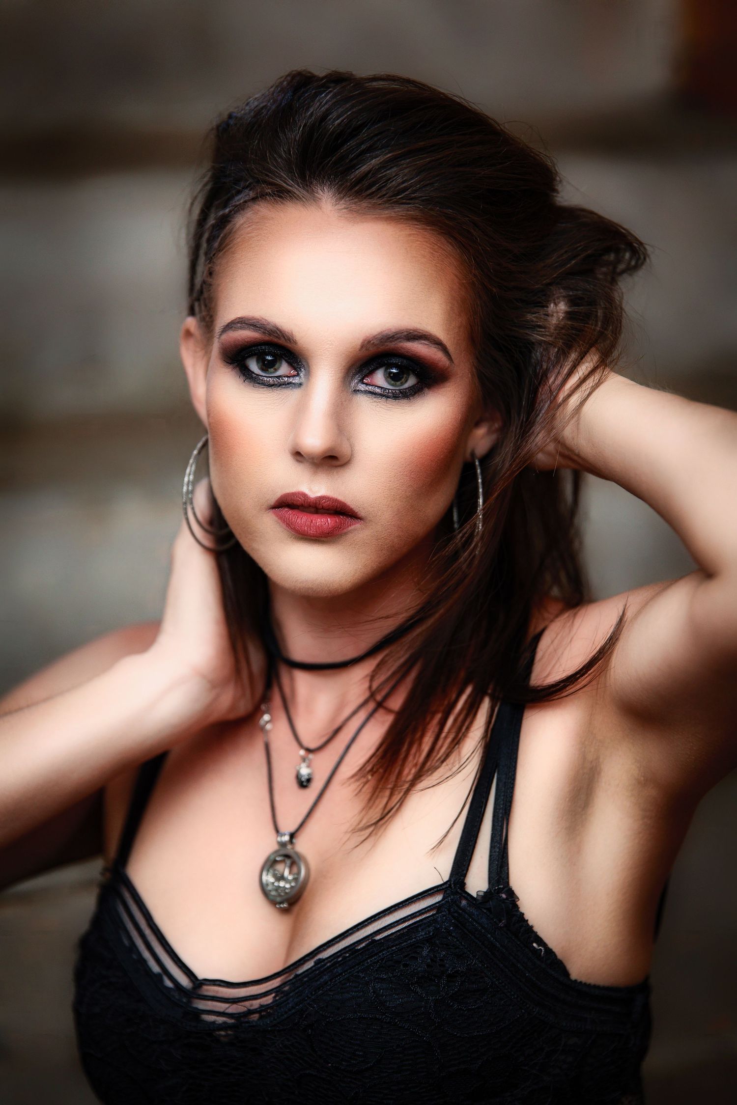 A dramatic portrait series featuring gothic-inspired makeup with dark smokey eyes and deep red lipstick against a blurred background.