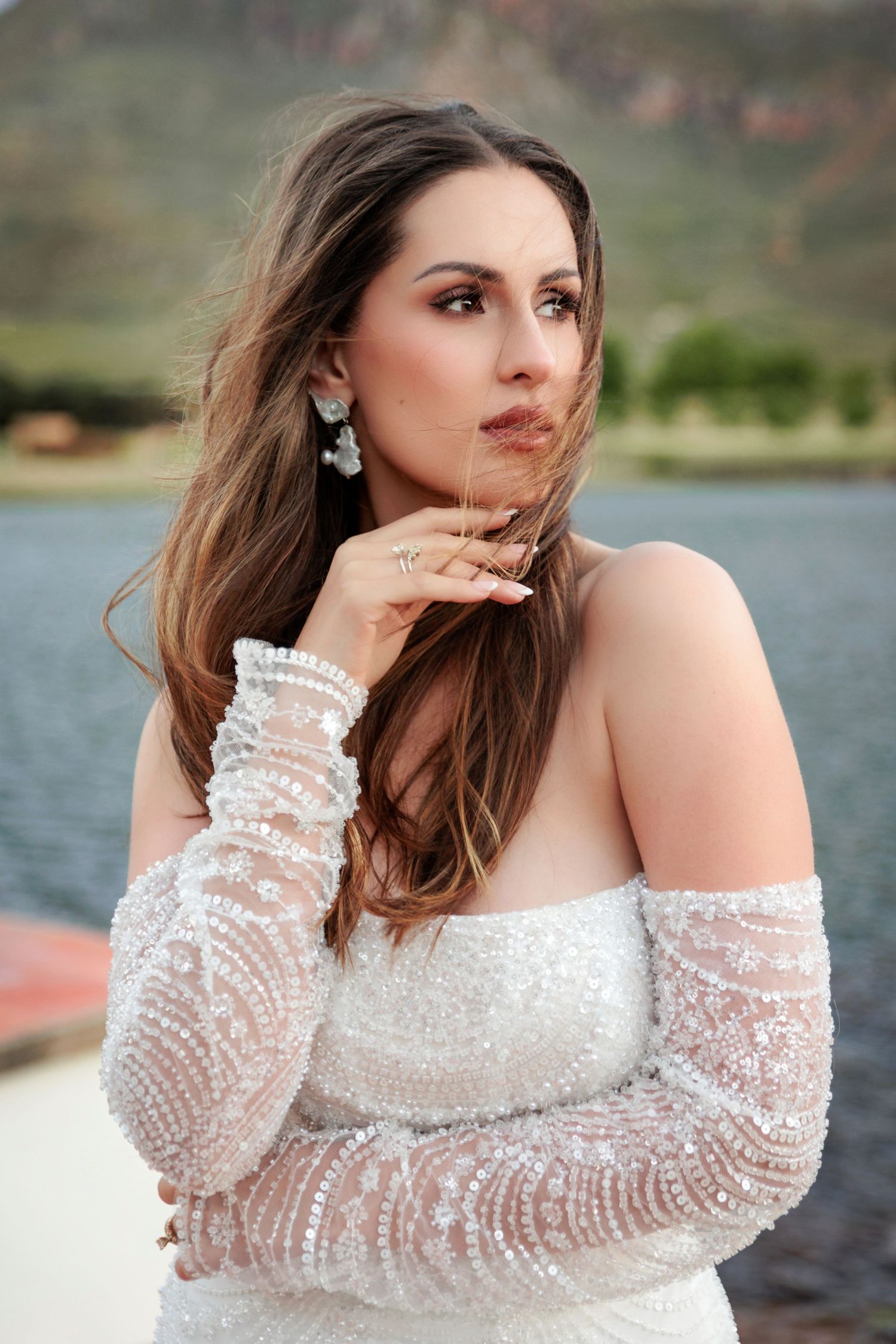 A series of outdoor portraits featuring a woman in a white beaded off-shoulder dress by a lake at sunset.