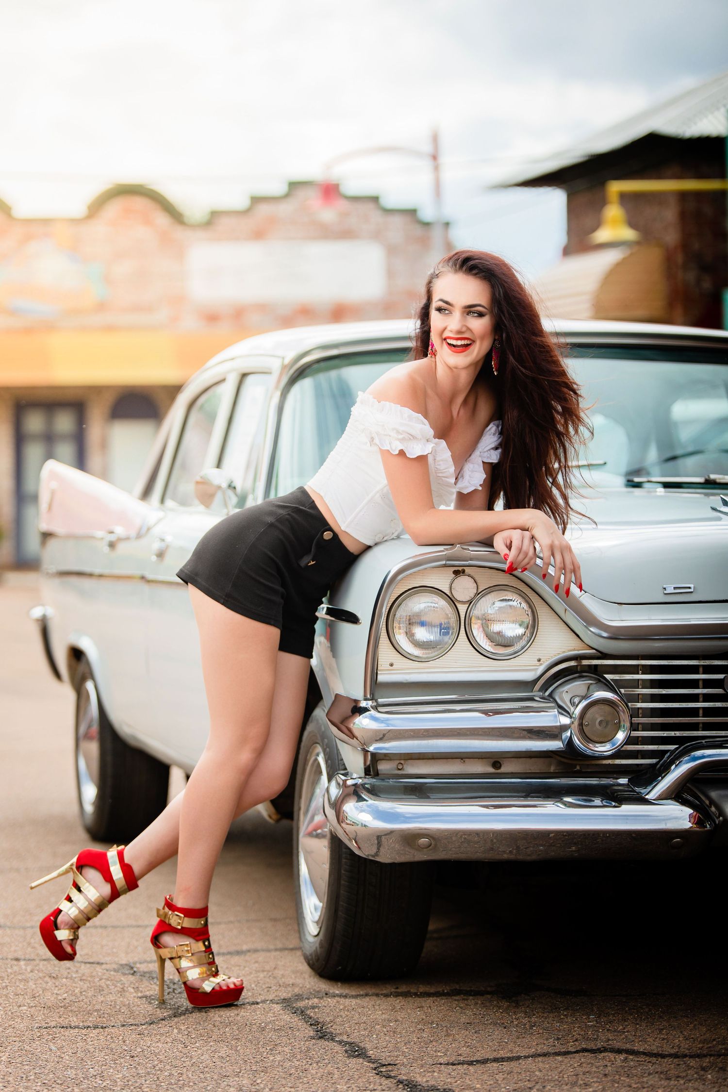 Vintage car photoshoot with red high heels and classic American automobiles in retro style.