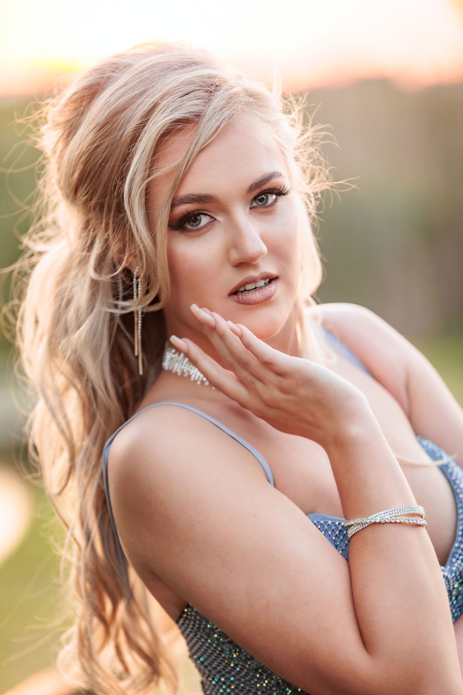 A woman in natural lighting poses outdoors with a playful and candid expression during a photo session.