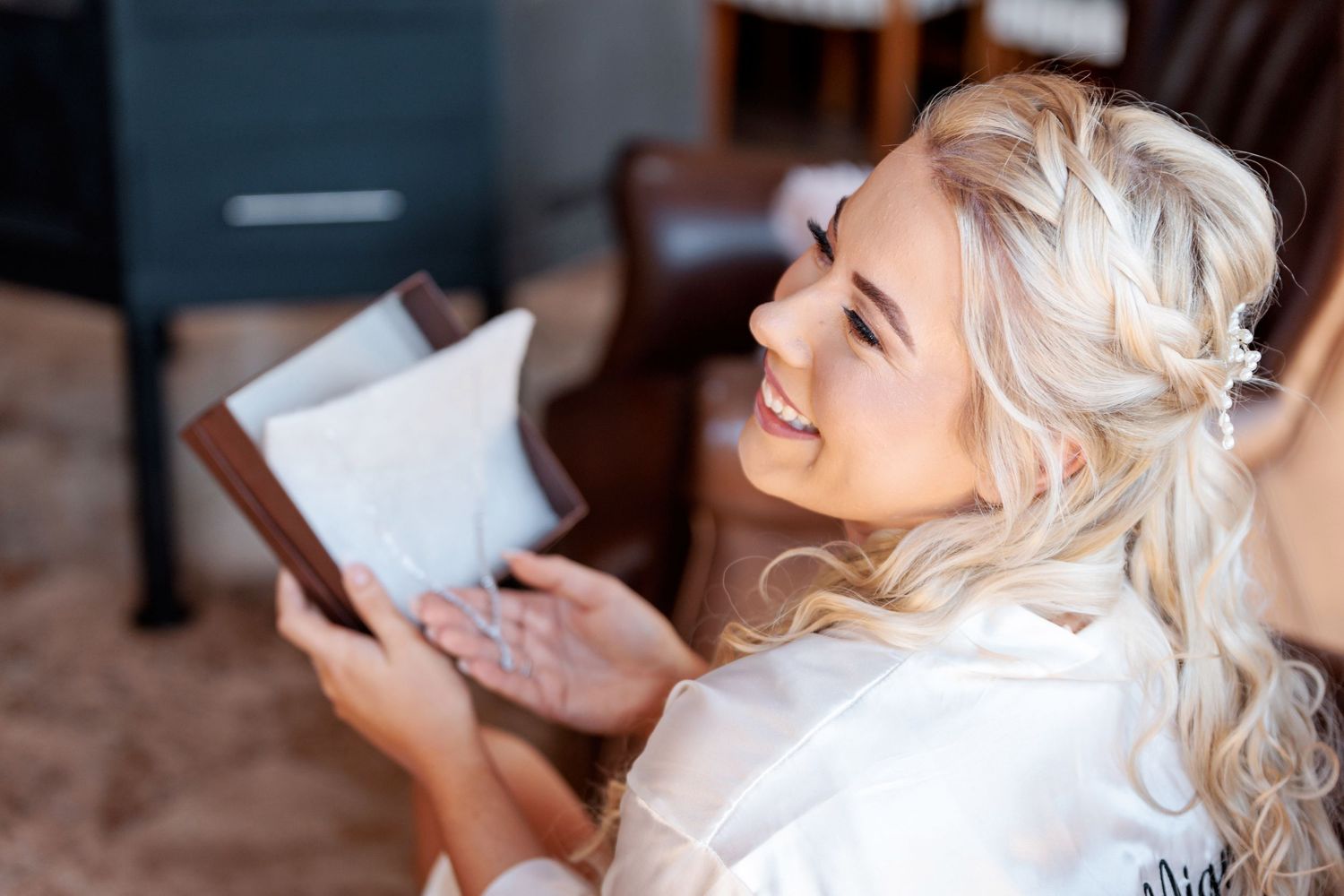 A joyful moment of reading a letter while getting ready in a silk robe.