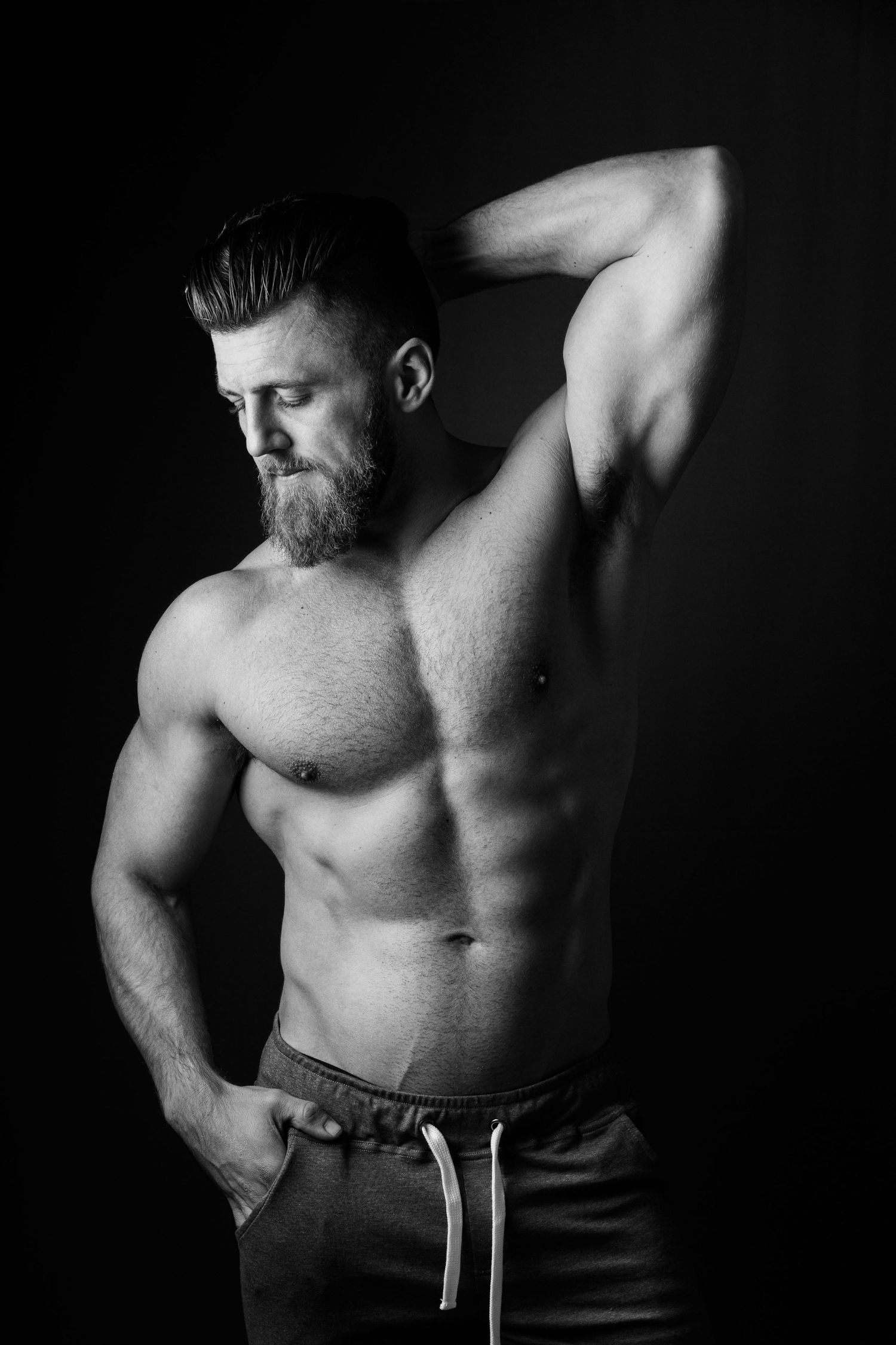 Artistic black and white photo series showing muscular male torso in dramatic lighting against dark background.