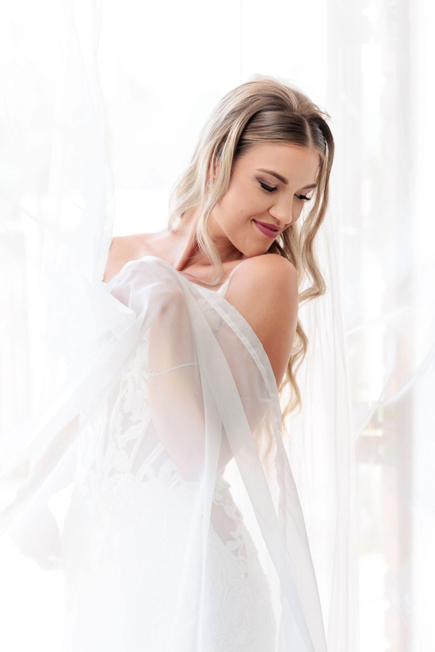 Ethereal portrait series of woman in white against soft window light creating dreamy romantic atmosphere.