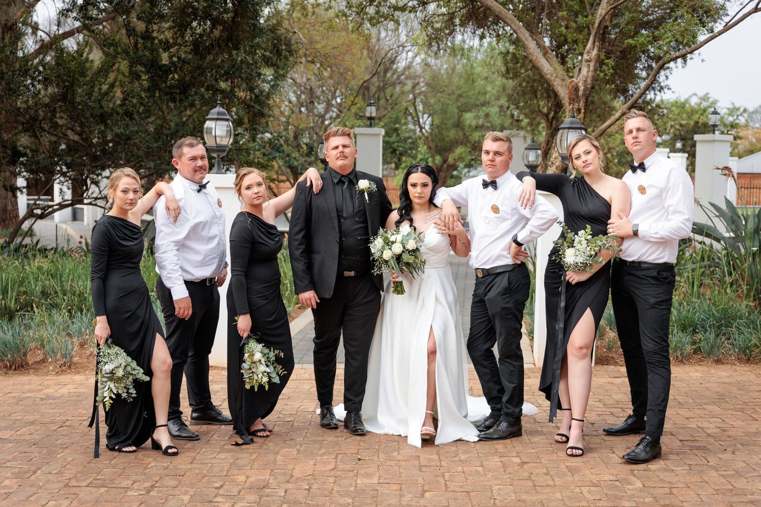 Wedding party group photos outdoors with natural landscape backdrop.