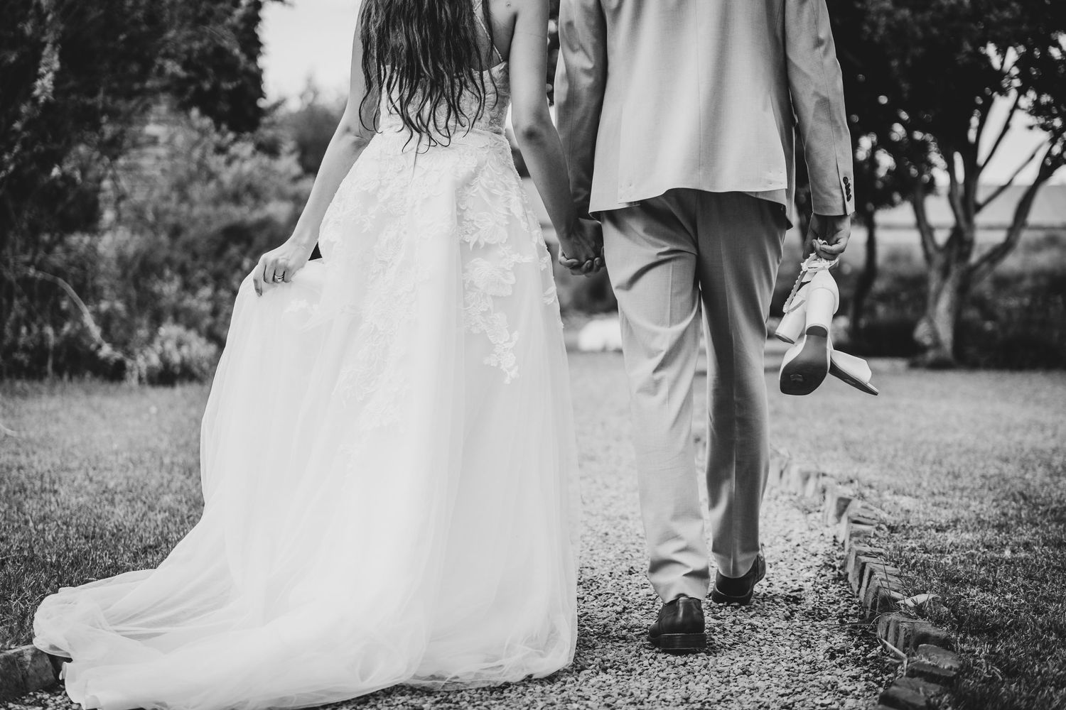 A couple in wedding attire share a romantic dance moment outdoors.