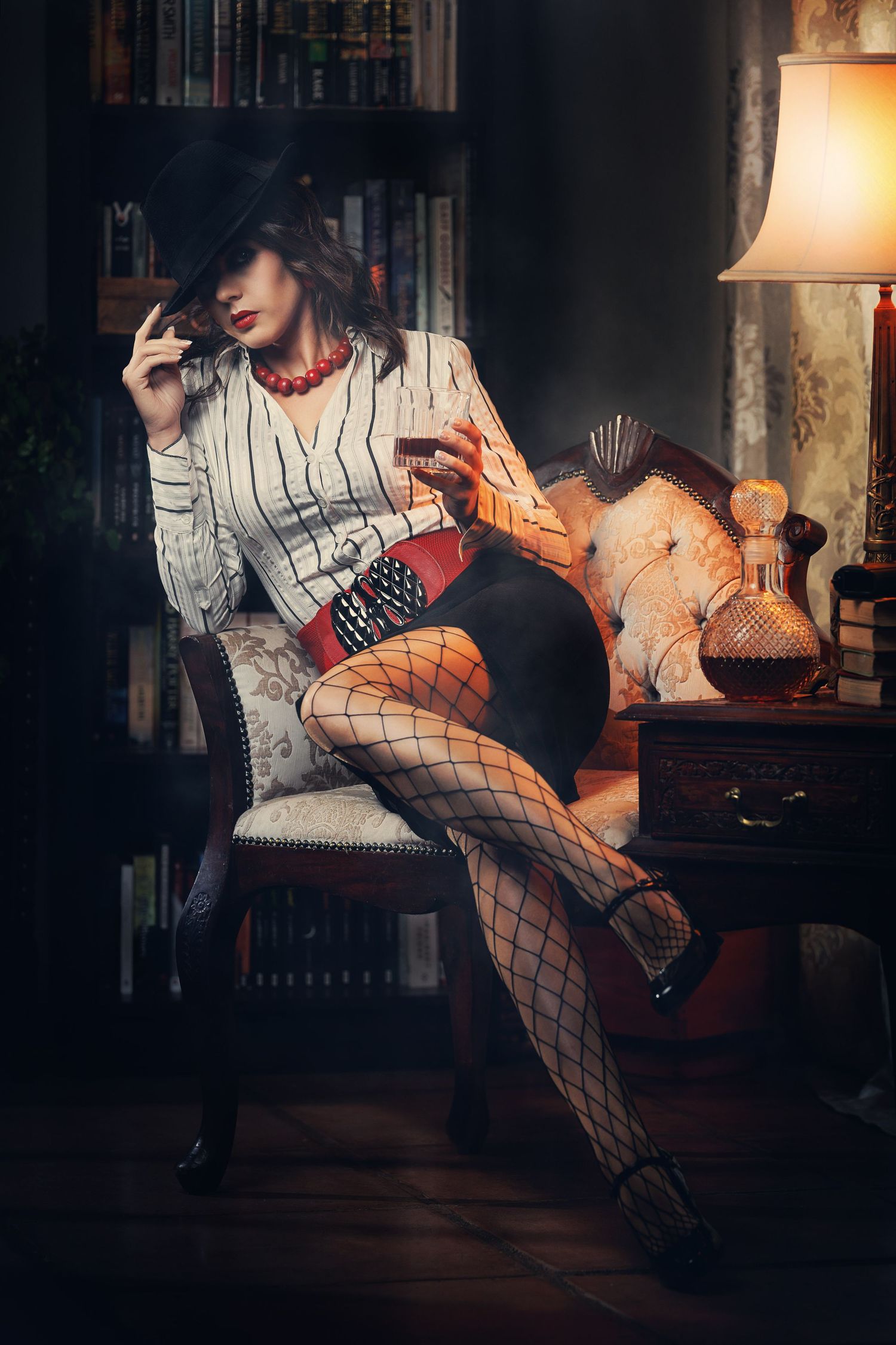 A moody boudoir photoshoot series featuring fishnet stockings and dramatic lighting in a dimly lit room.