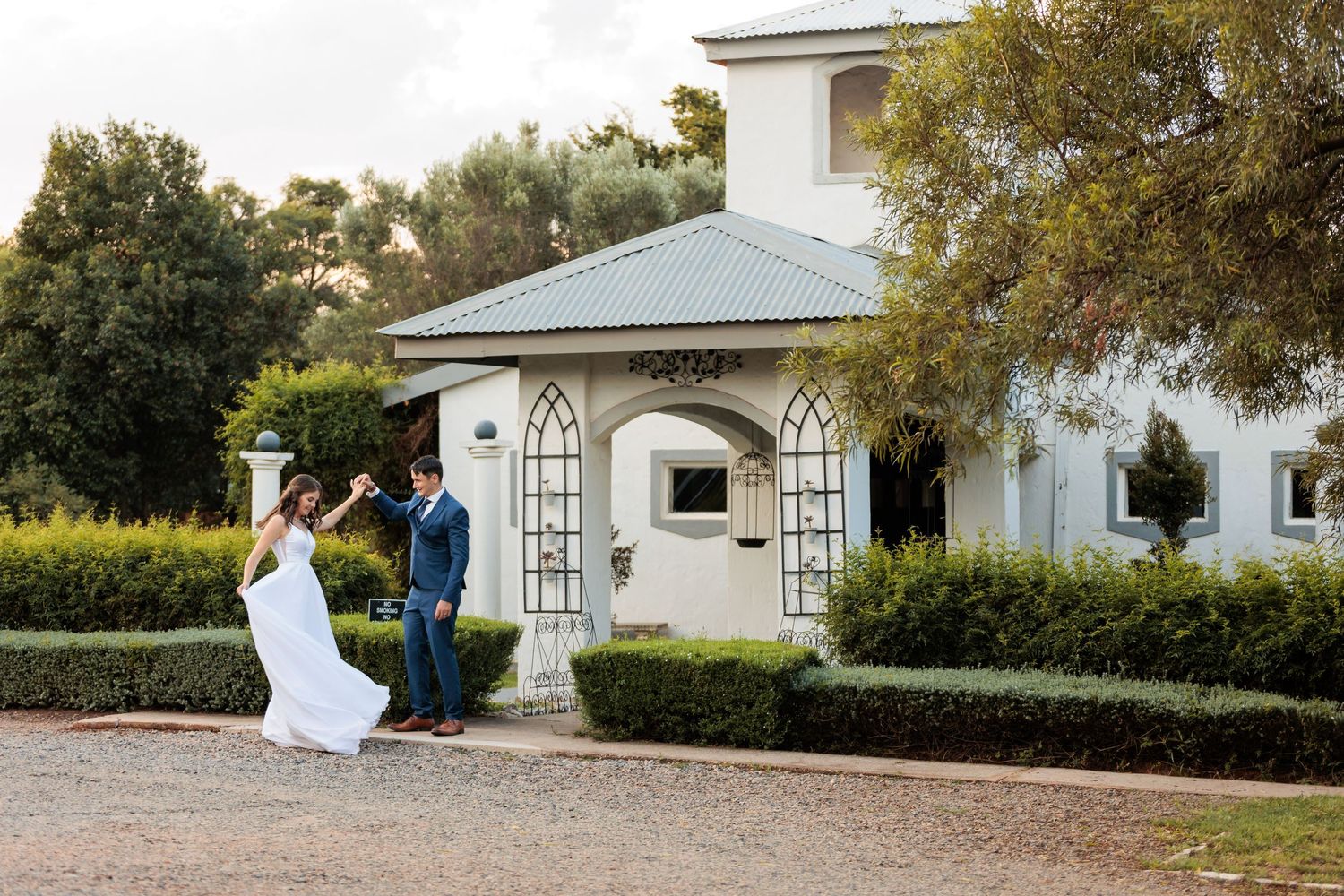 Classic white chapel provides elegant backdrop for outdoor wedding photography.