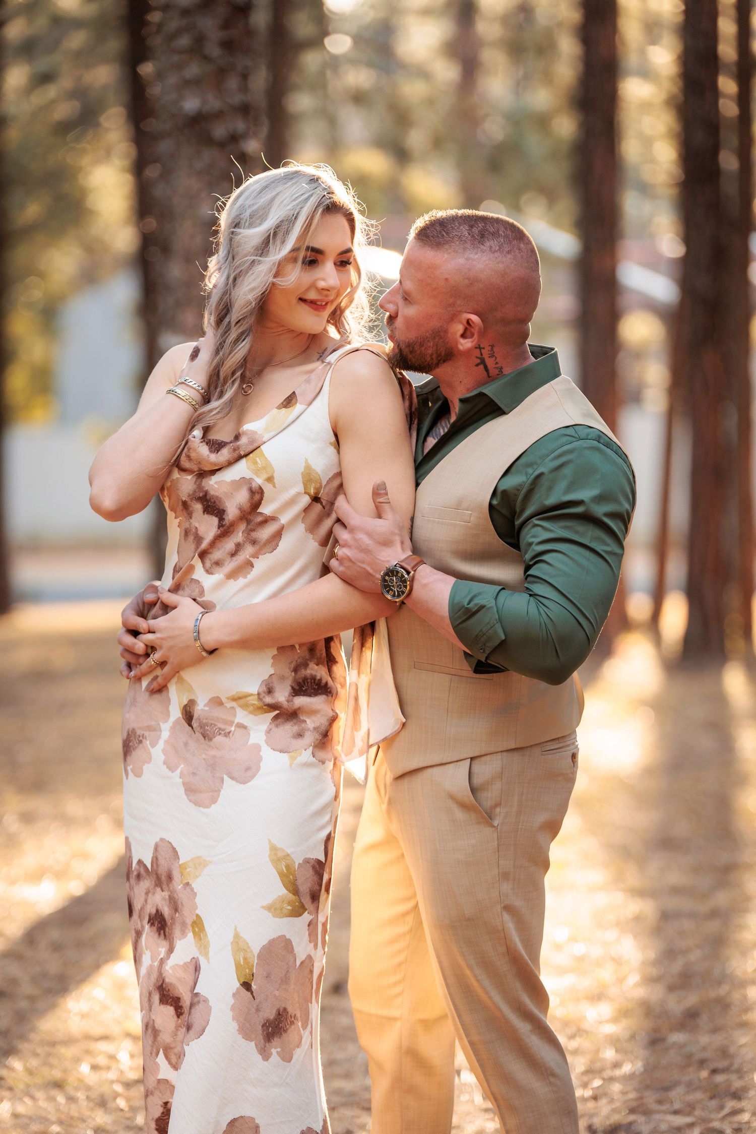 Romantic couple embraces in a sun-drenched forest during golden hour, creating a magical moment in nature.