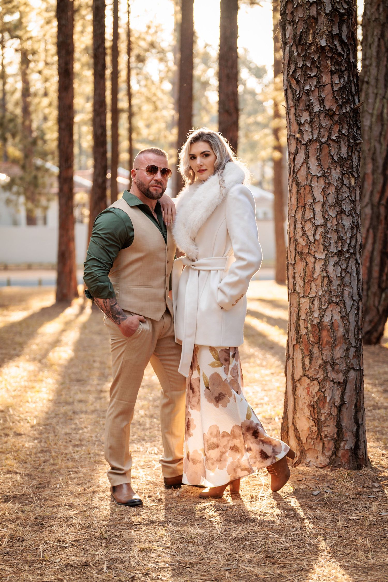 A couple shares playful moments among tall pine trees at sunset, creating a romantic autumn forest photoshoot.