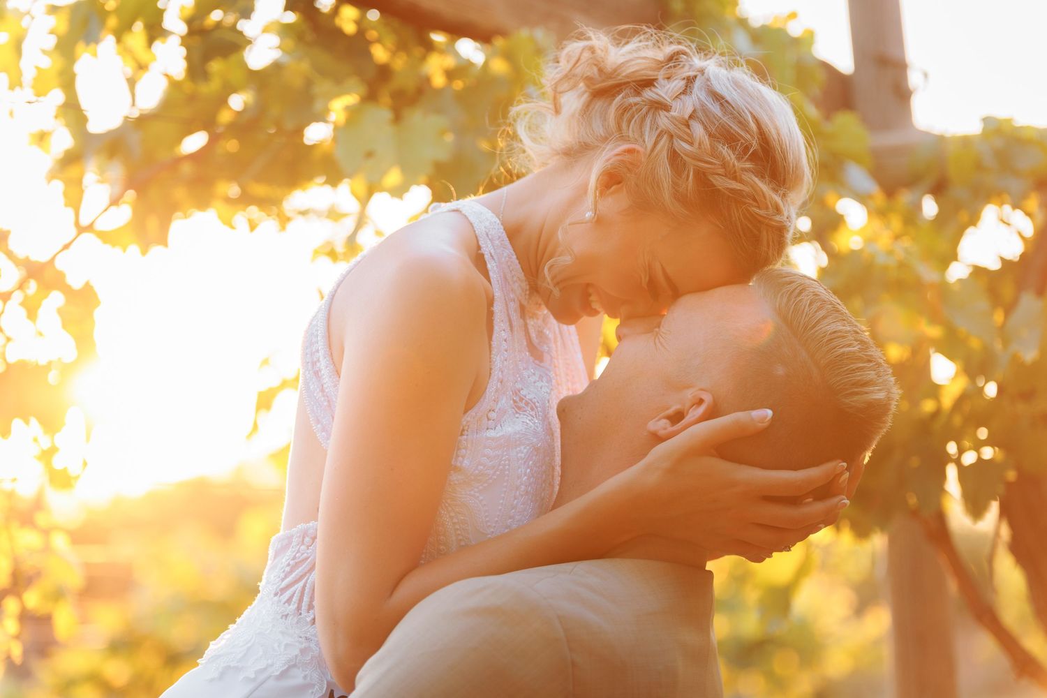 Romantic sunset moment in a vineyard with soft golden light filtering through the grapevines.